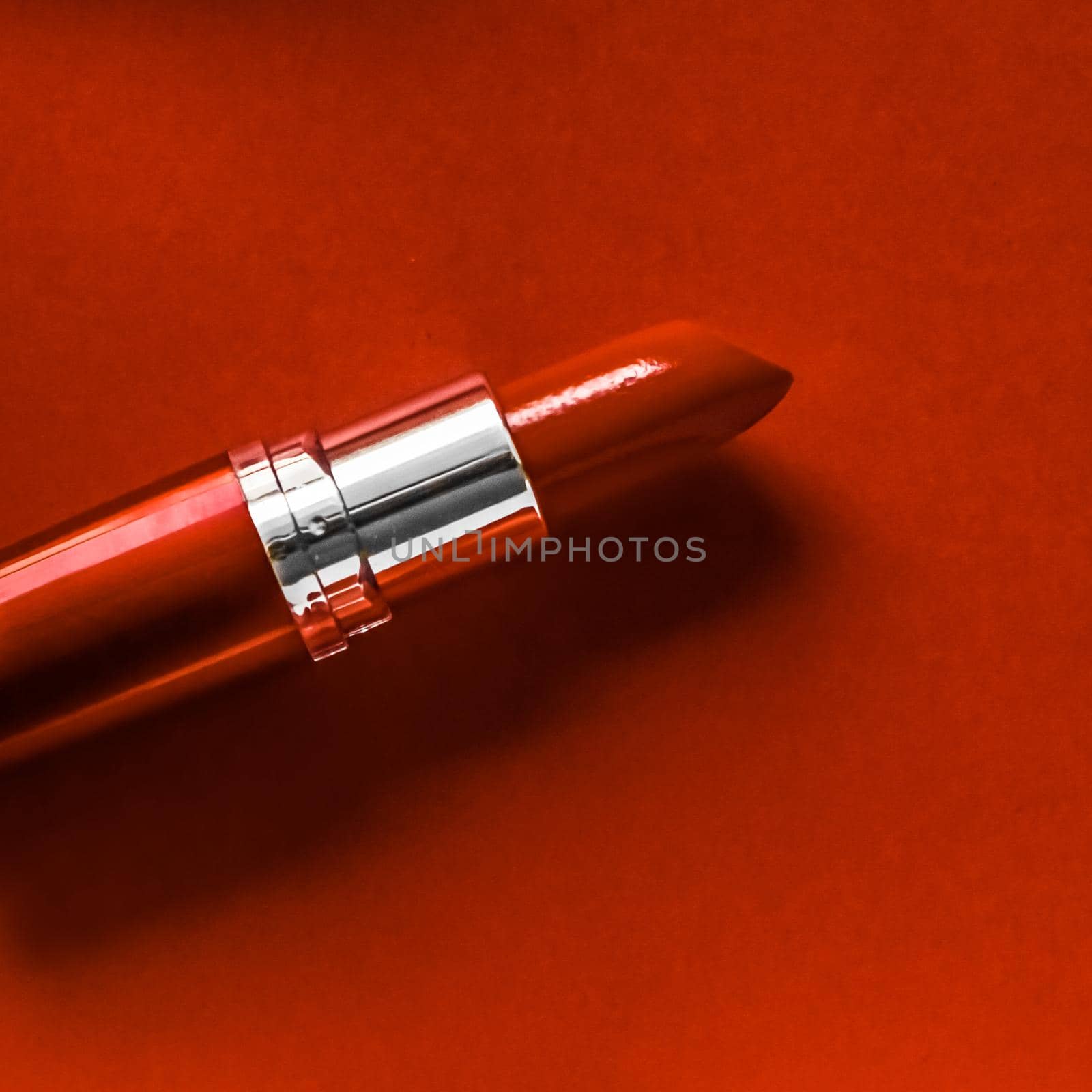 Cosmetic branding, glamour lip gloss and shopping sale concept - Luxury lipstick and silk ribbon on orange holiday background, make-up and cosmetics flatlay for beauty brand product design