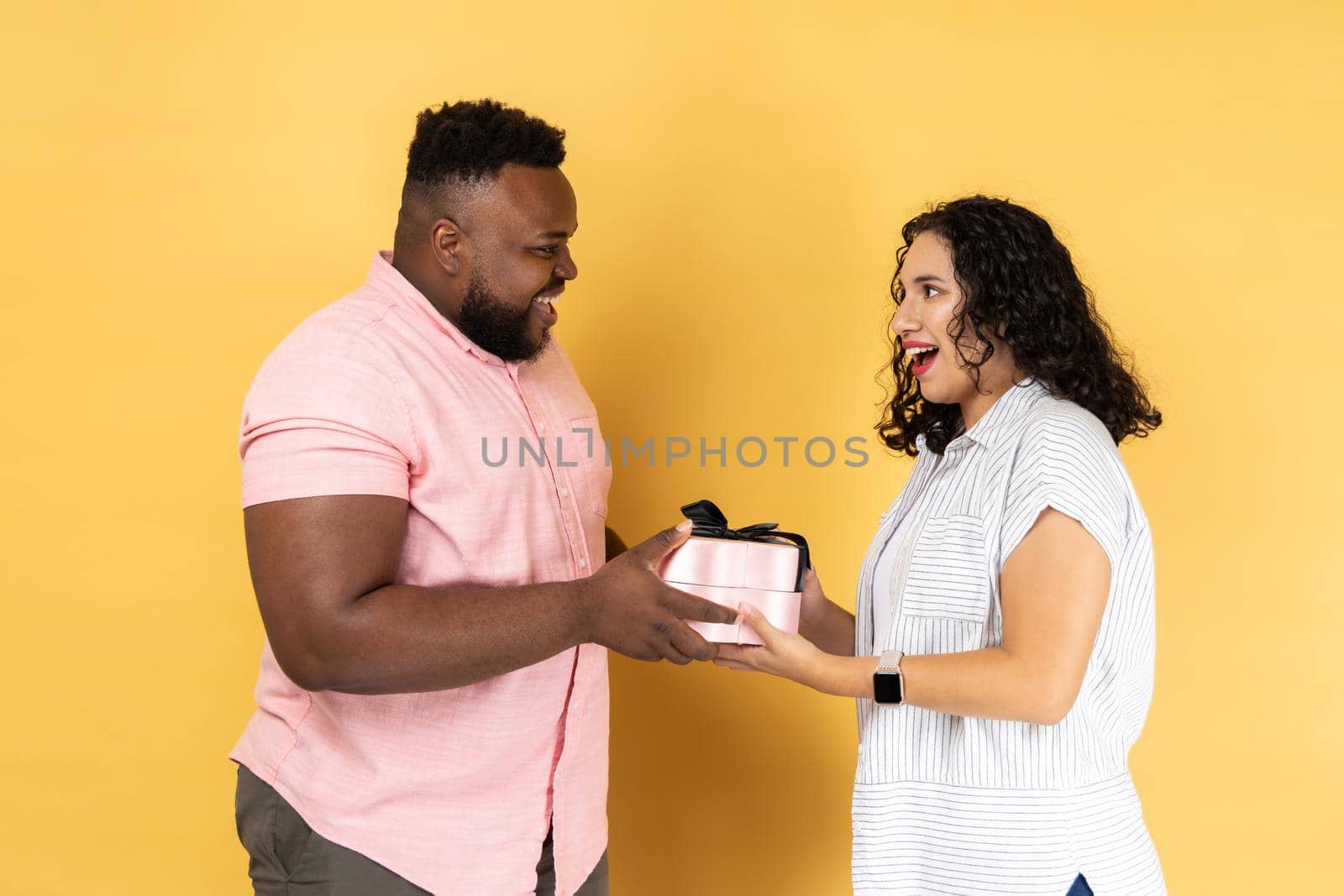 Romantic young couple standing together, husband giving present box, congratulating with anniversary by Khosro1