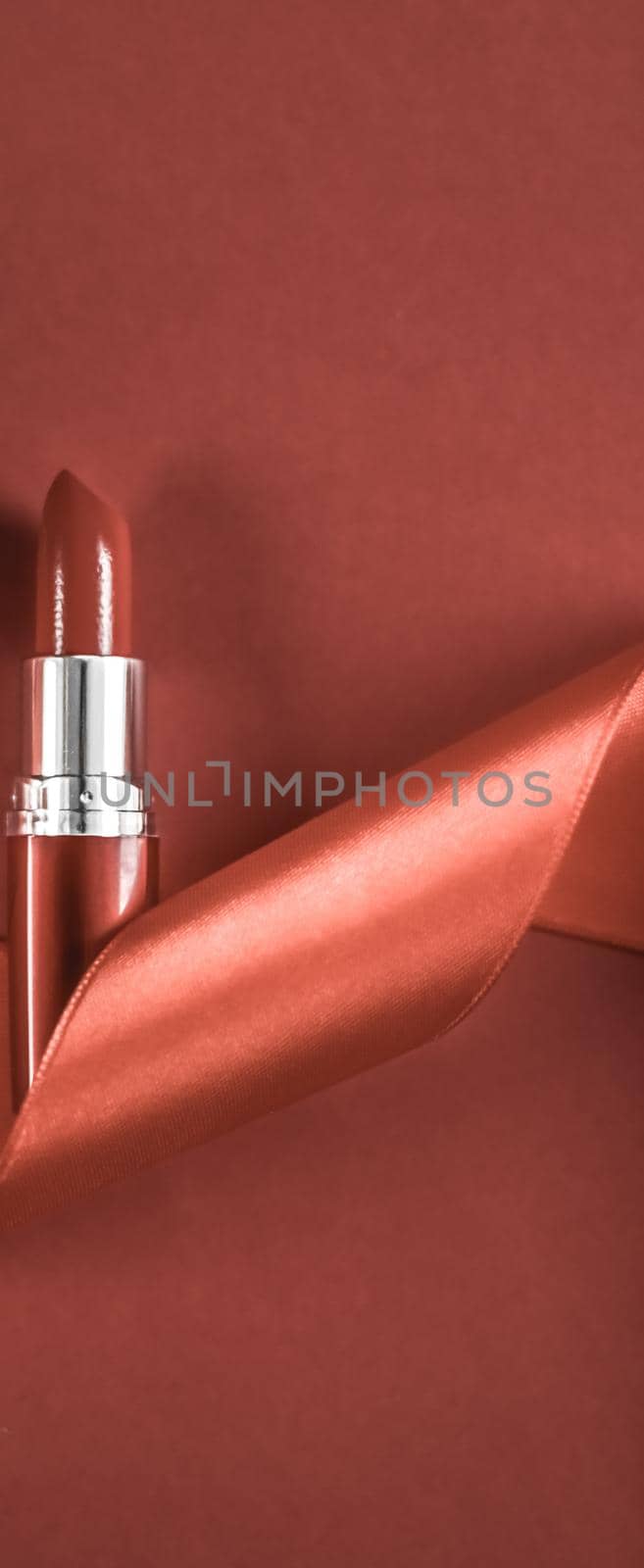 Cosmetic branding, glamour lip gloss and shopping sale concept - Luxury lipstick and silk ribbon on bronze holiday background, make-up and cosmetics flatlay for beauty brand product design