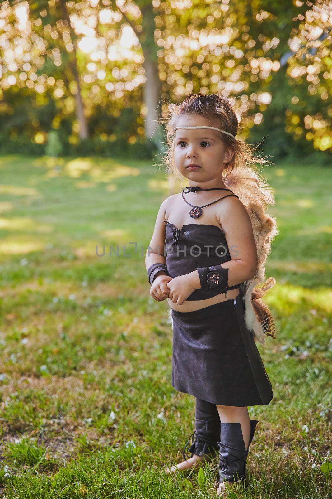 Cute baby dressed in the clothes of primitive people.