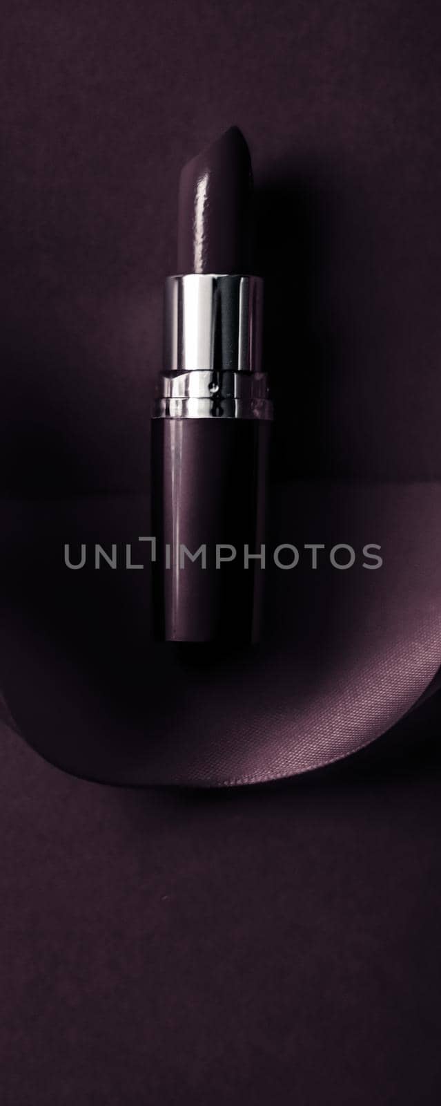 Cosmetic branding, glamour lip gloss and shopping sale concept - Luxury lipstick and silk ribbon on dark purple holiday background, make-up and cosmetics flatlay for beauty brand product design