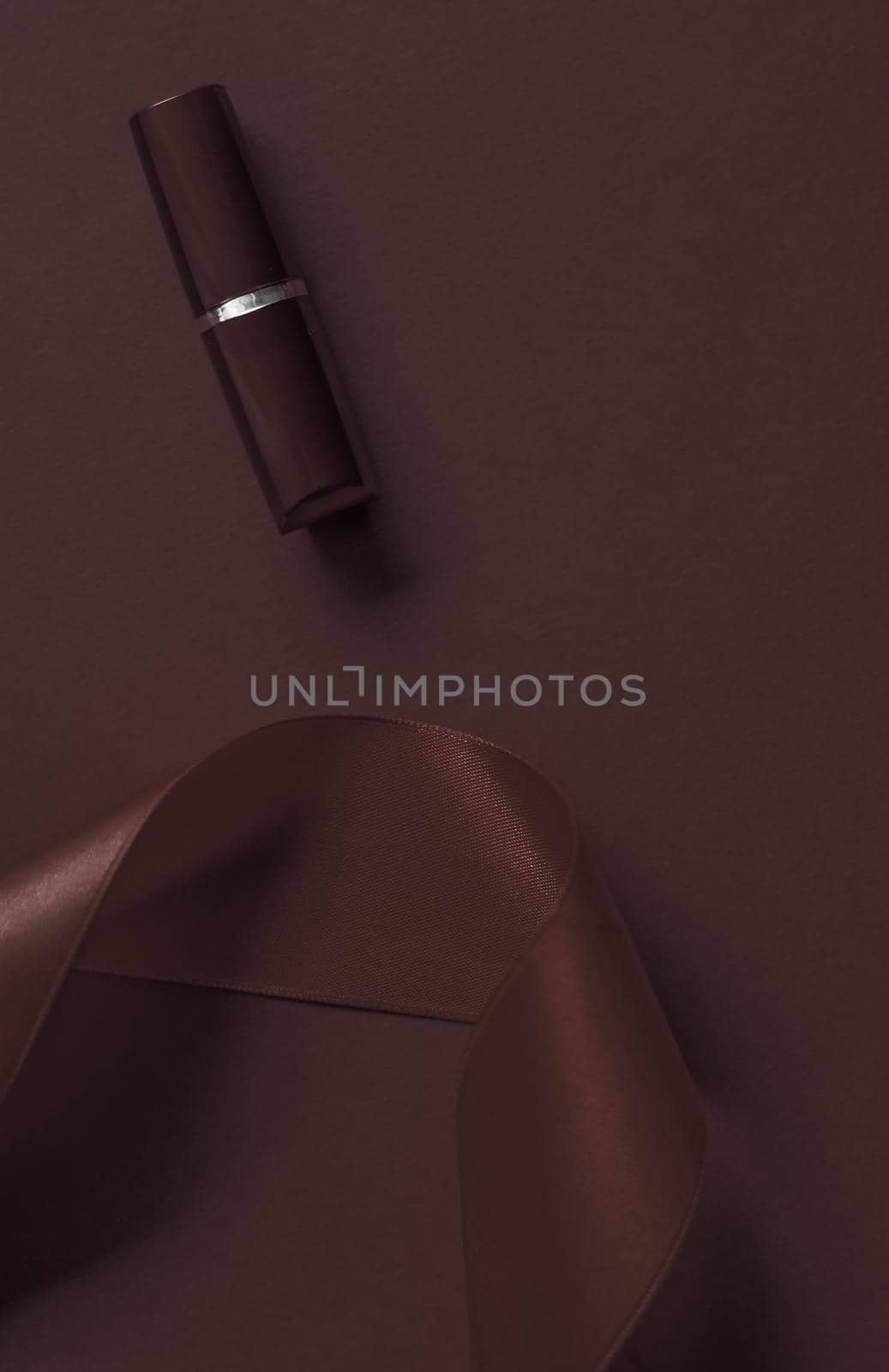 Cosmetic branding, glamour lip gloss and shopping sale concept - Luxury lipstick and silk ribbon on chocolate holiday background, make-up and cosmetics flatlay for beauty brand product design