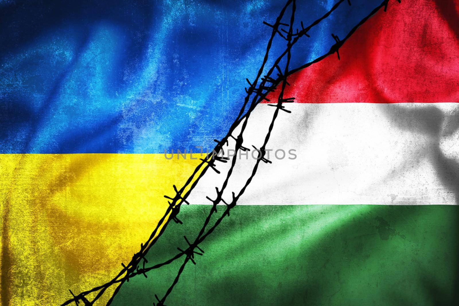 Grunge flags of Ukraine and Hungary divided by barb wire illustration by xbrchx