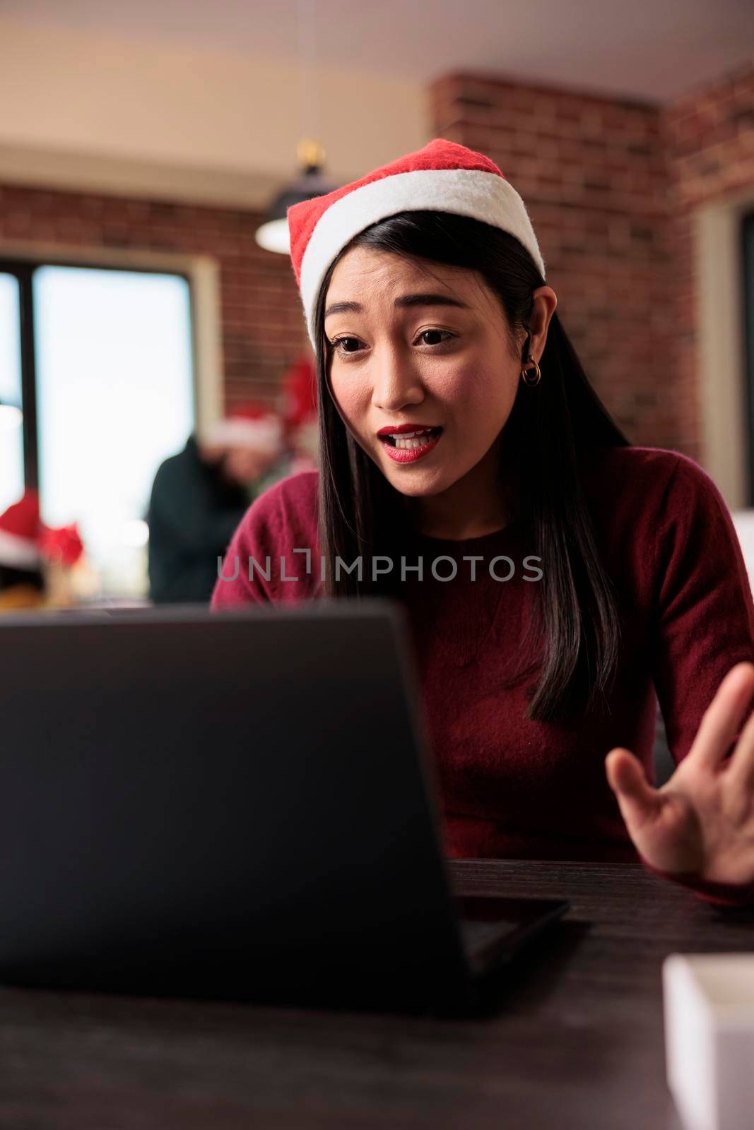 Asian employee attending videocall meeting in office by DCStudio