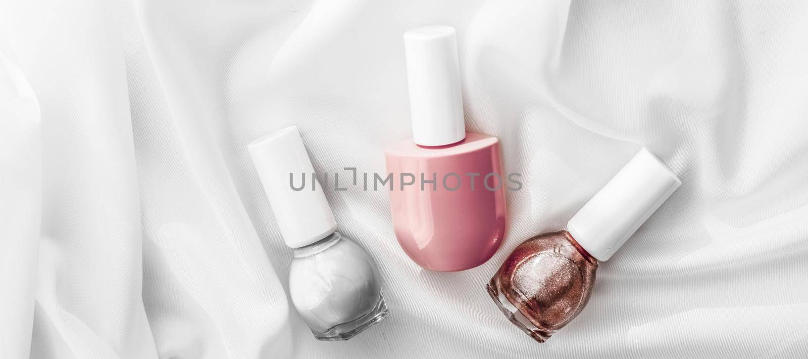 Cosmetic branding, salon and glamour concept - Nail polish bottles on silk background, french manicure products and nailpolish make-up cosmetics for luxury beauty brand and holiday flatlay art design