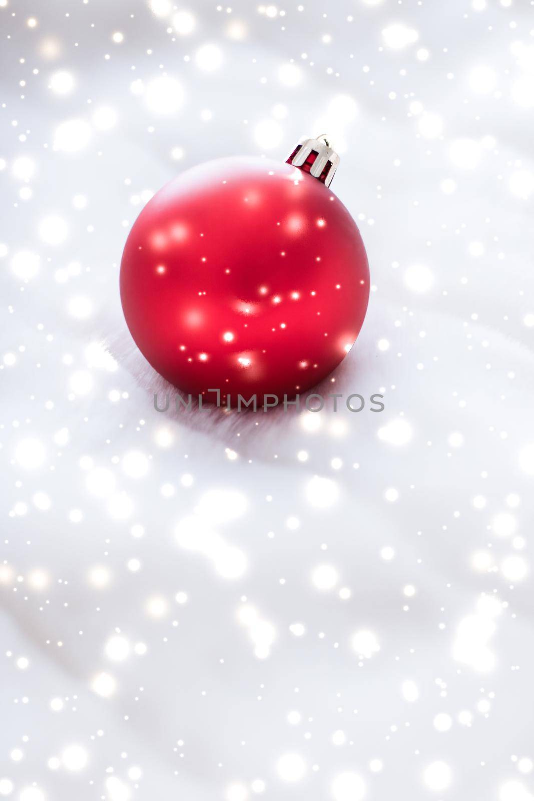 Gift decor, New Years Eve and happy celebration concept - Red Christmas baubles on fluffy fur with snow glitter, luxury winter holiday design background