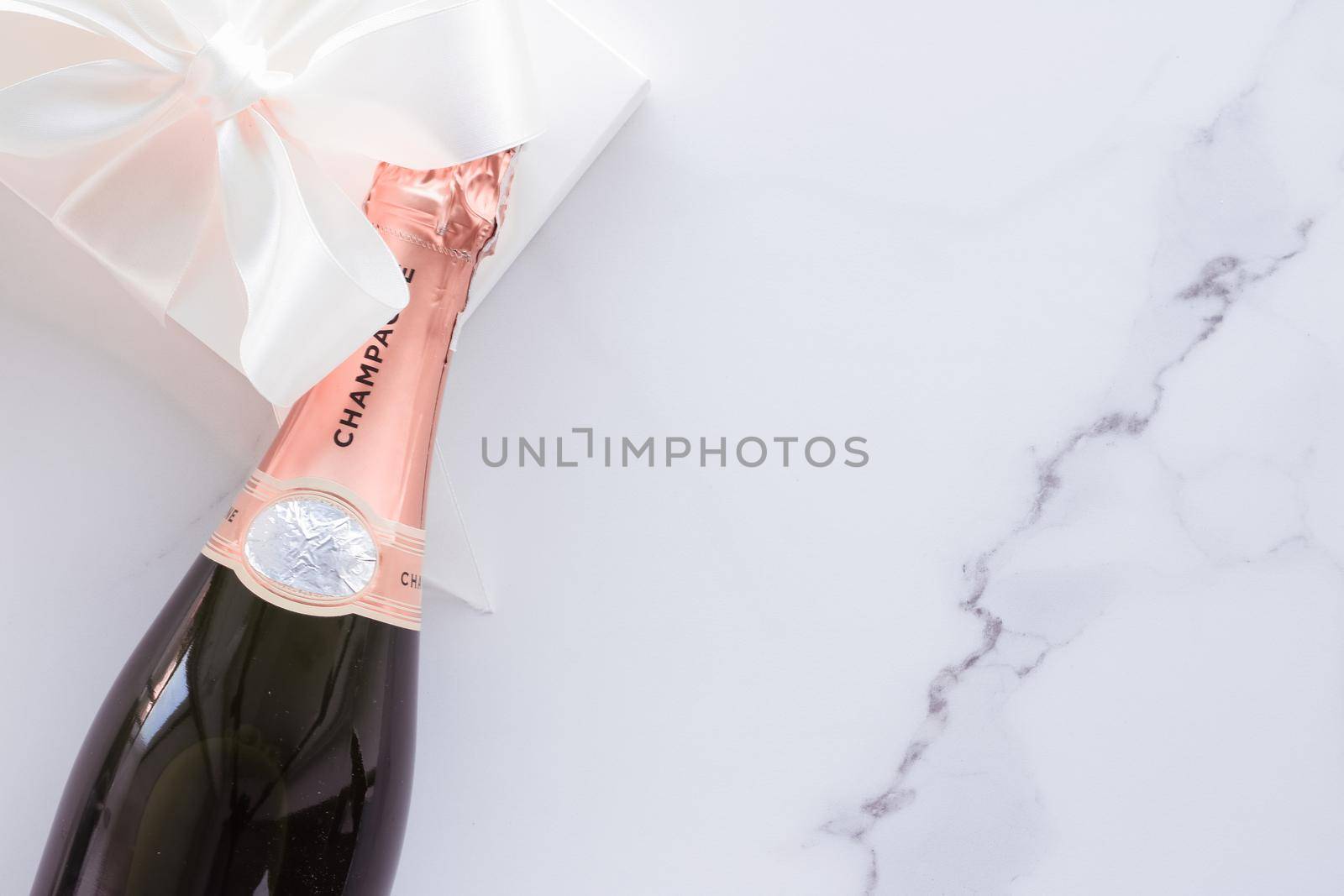 Celebration, drink and branding concept - Champagne bottle and gift box on marble, New Years, Christmas, Valentines Day or wedding holiday present and luxury product packaging for beverage brand