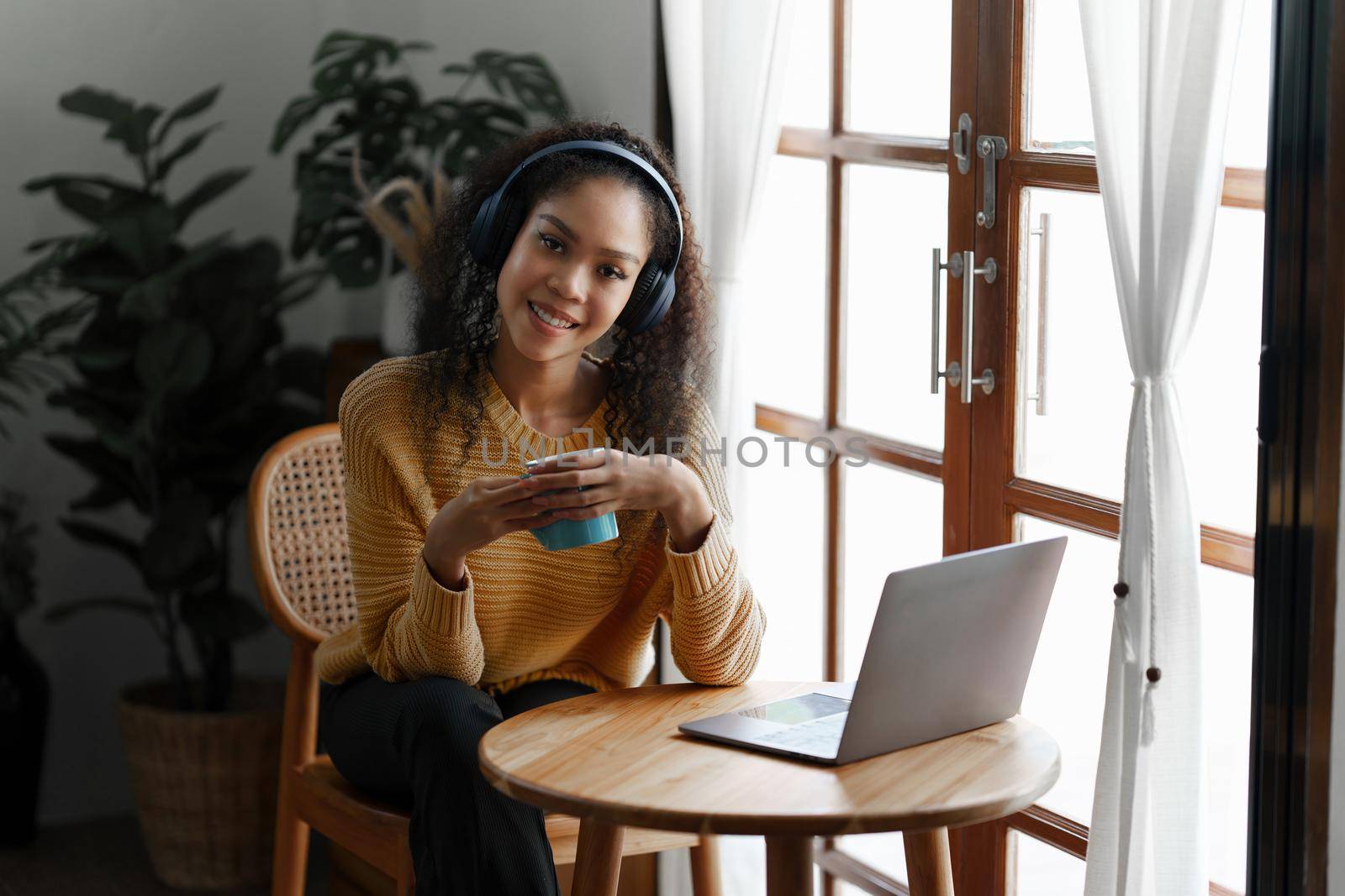 Beautiful woman using laptop and listening music with earphones by itchaznong