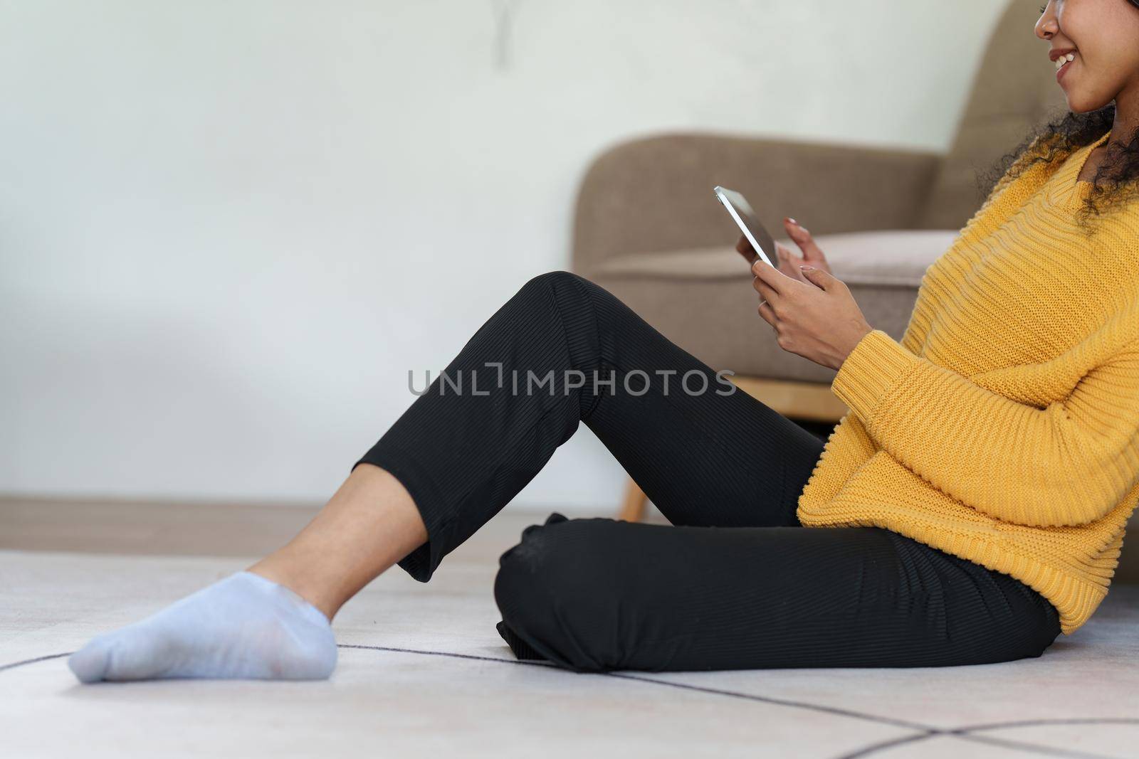 Attractive smiling young woman using tablet and listen music on sofa at home. lifestyle concept by itchaznong