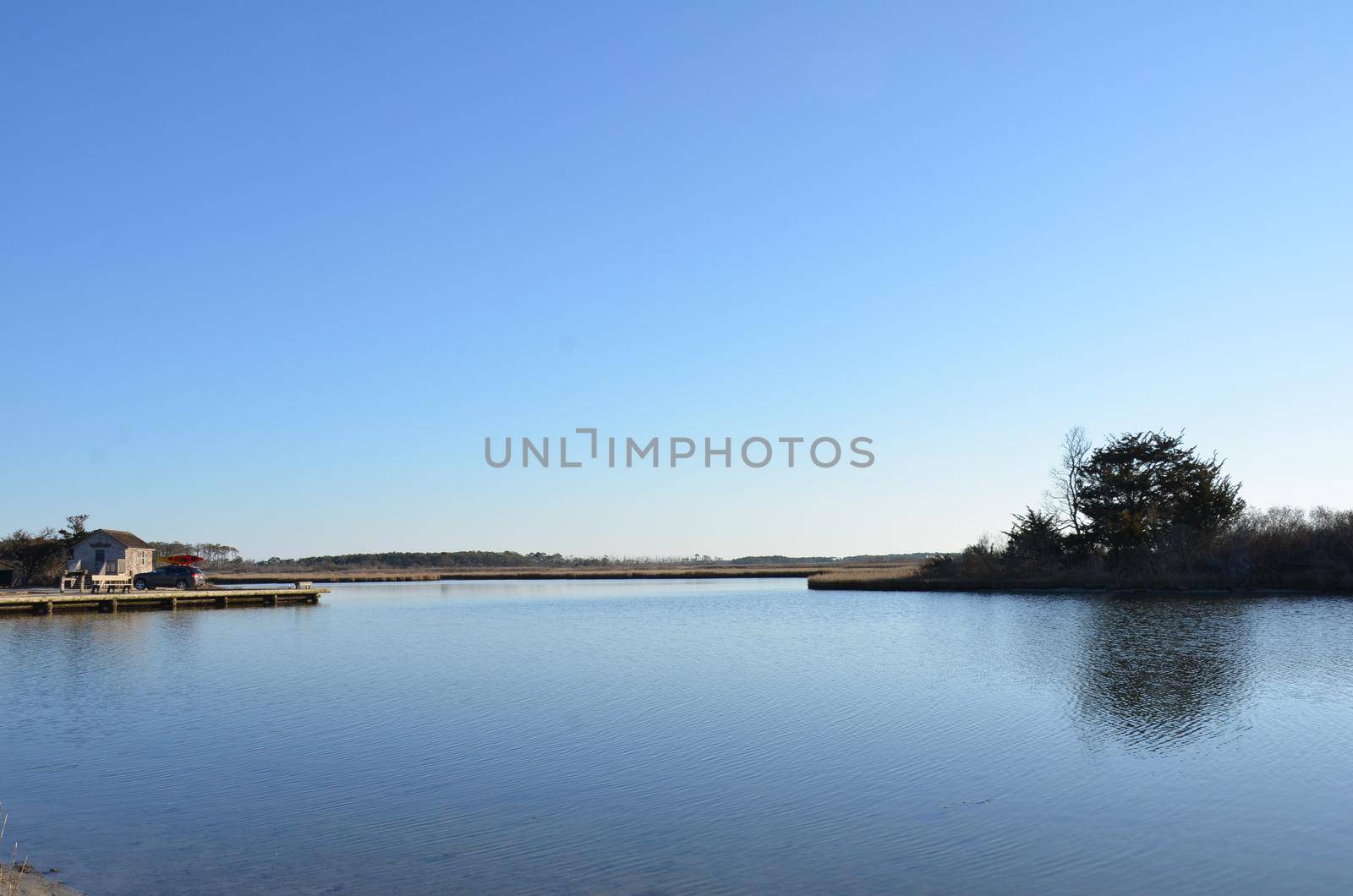 a lake or river with brown grasses and shore by stockphotofan1