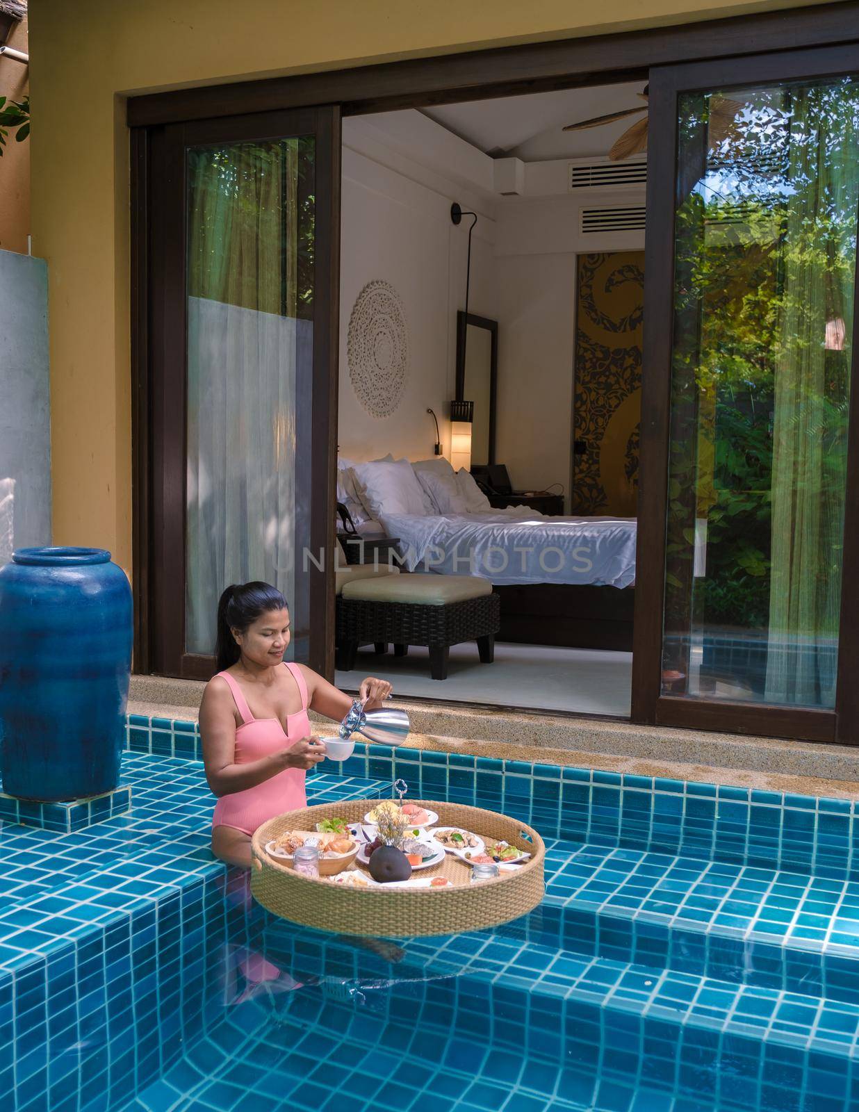 women having breakfast in swimming pool , Asian women having floating breakfast by fokkebok