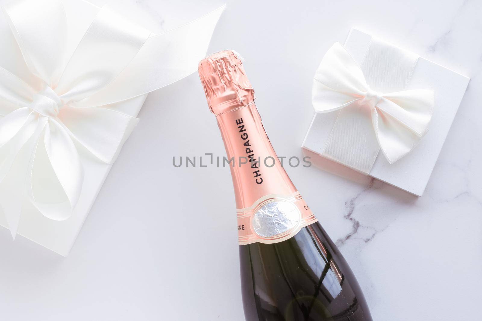 Celebration, drink and branding concept - Champagne bottle and gift box on marble, New Years, Christmas, Valentines Day or wedding holiday present and luxury product packaging for beverage brand