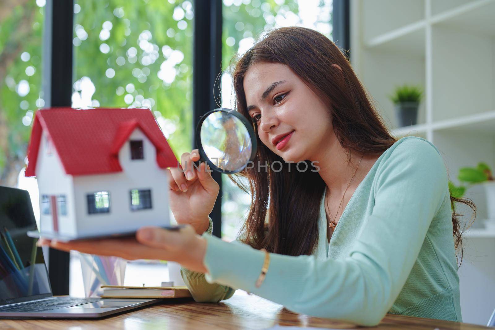 customer holding a magnifying glass to look at a house model inspection by Manastrong
