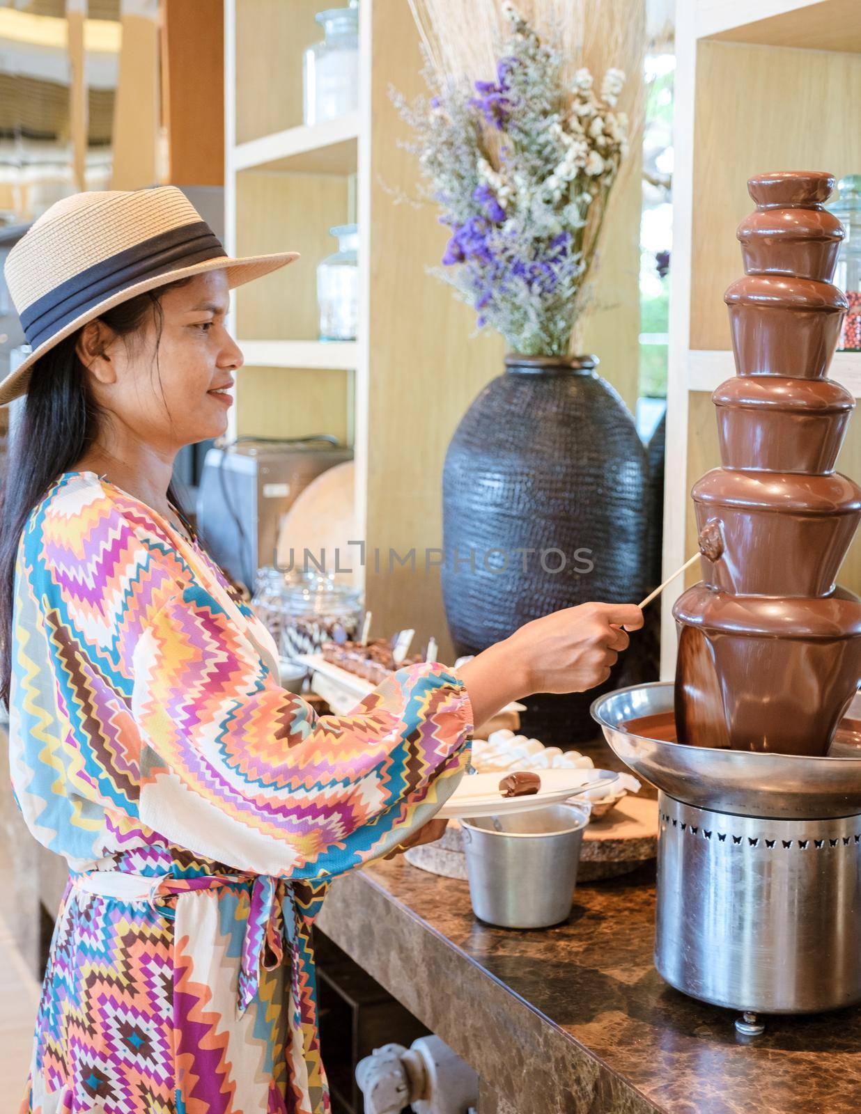 Asian women by chocolate bar, chocolate fountain by fokkebok