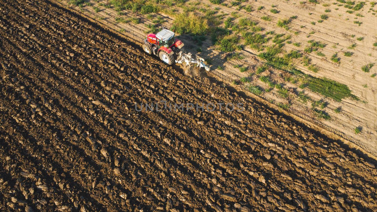 Aerial view with drone of tractor plowing the land in the countryside.