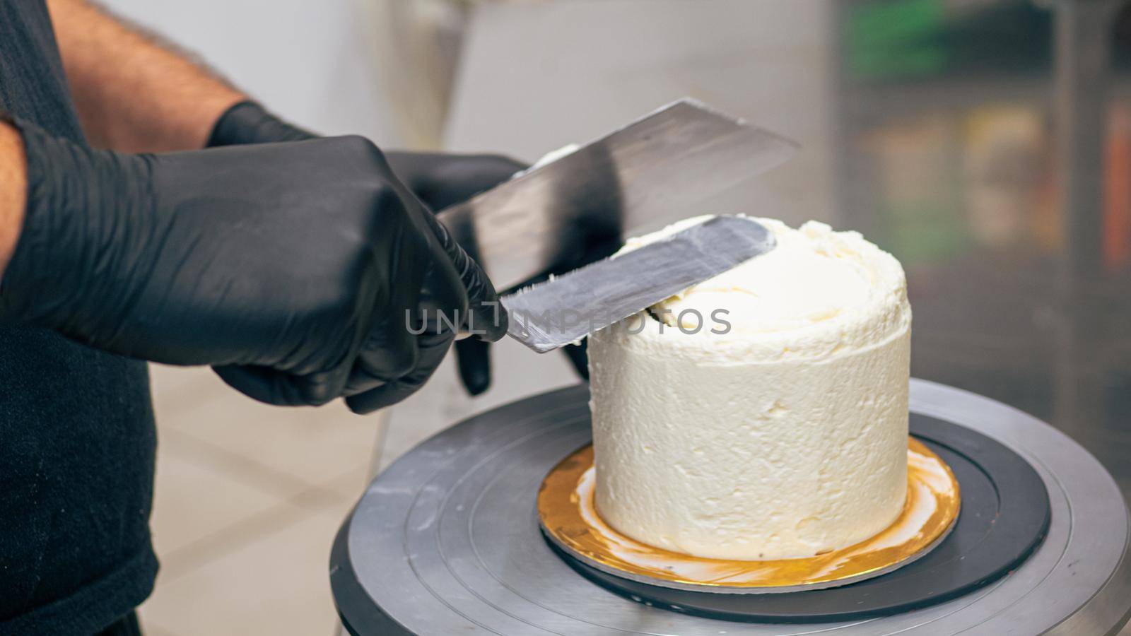 professional baker decorating a chocolate and cream cake with salty caramel