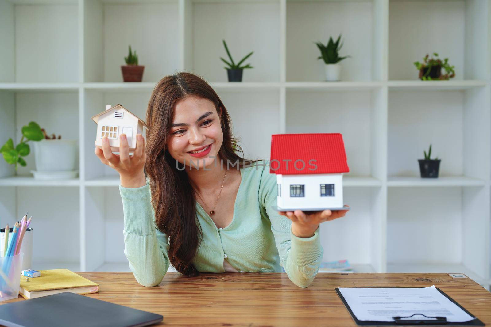 The client select a house model, inspector concept of a home before making a decision to invest, make a loan, get insurance and sign important documents with the bank
