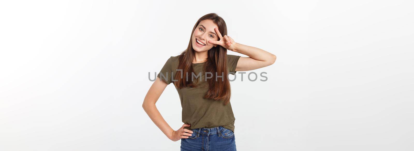 Young woman showing two fingers, positive or peace gesture, on white