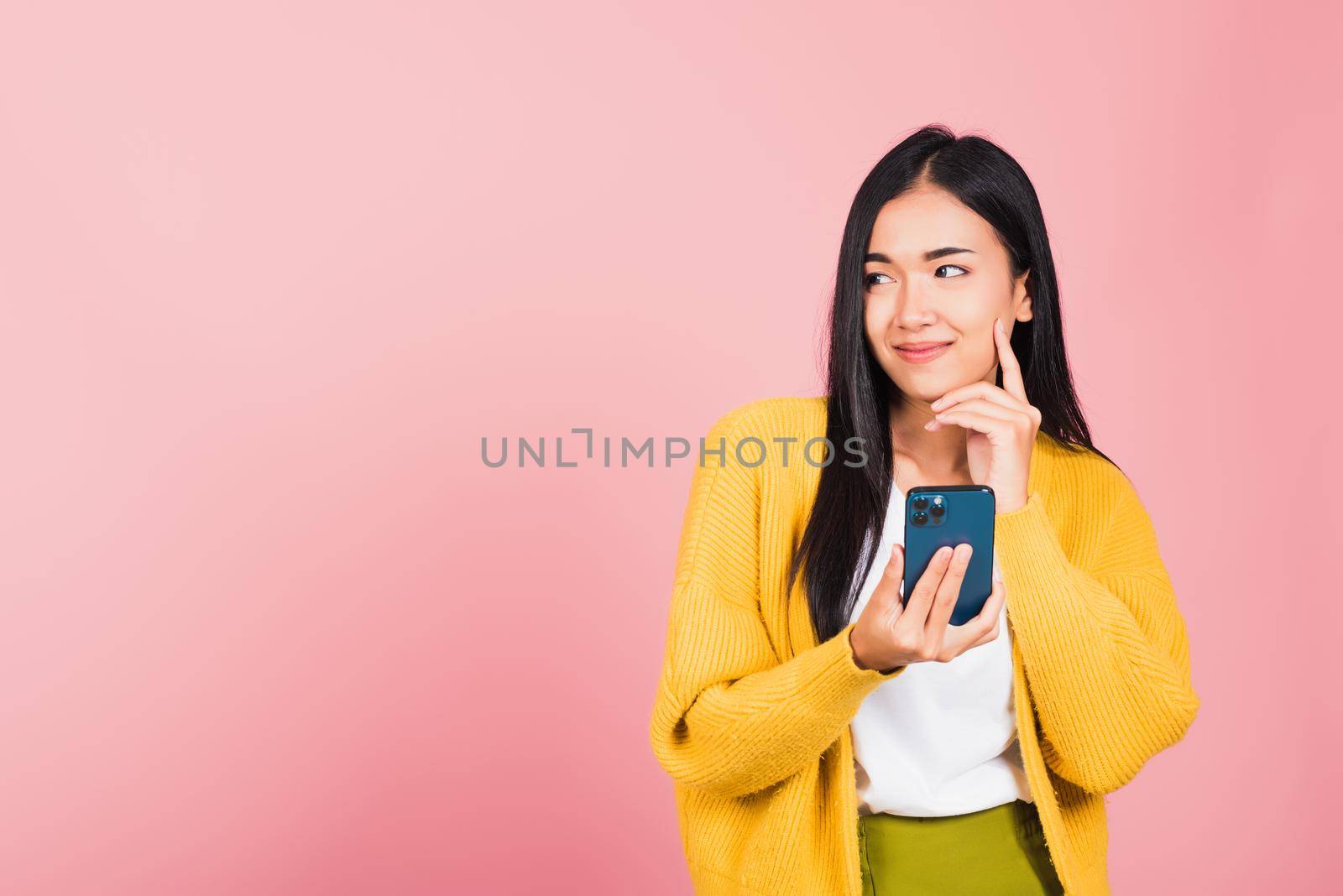 woman excited smiling holding mobile phone and think idea by Sorapop