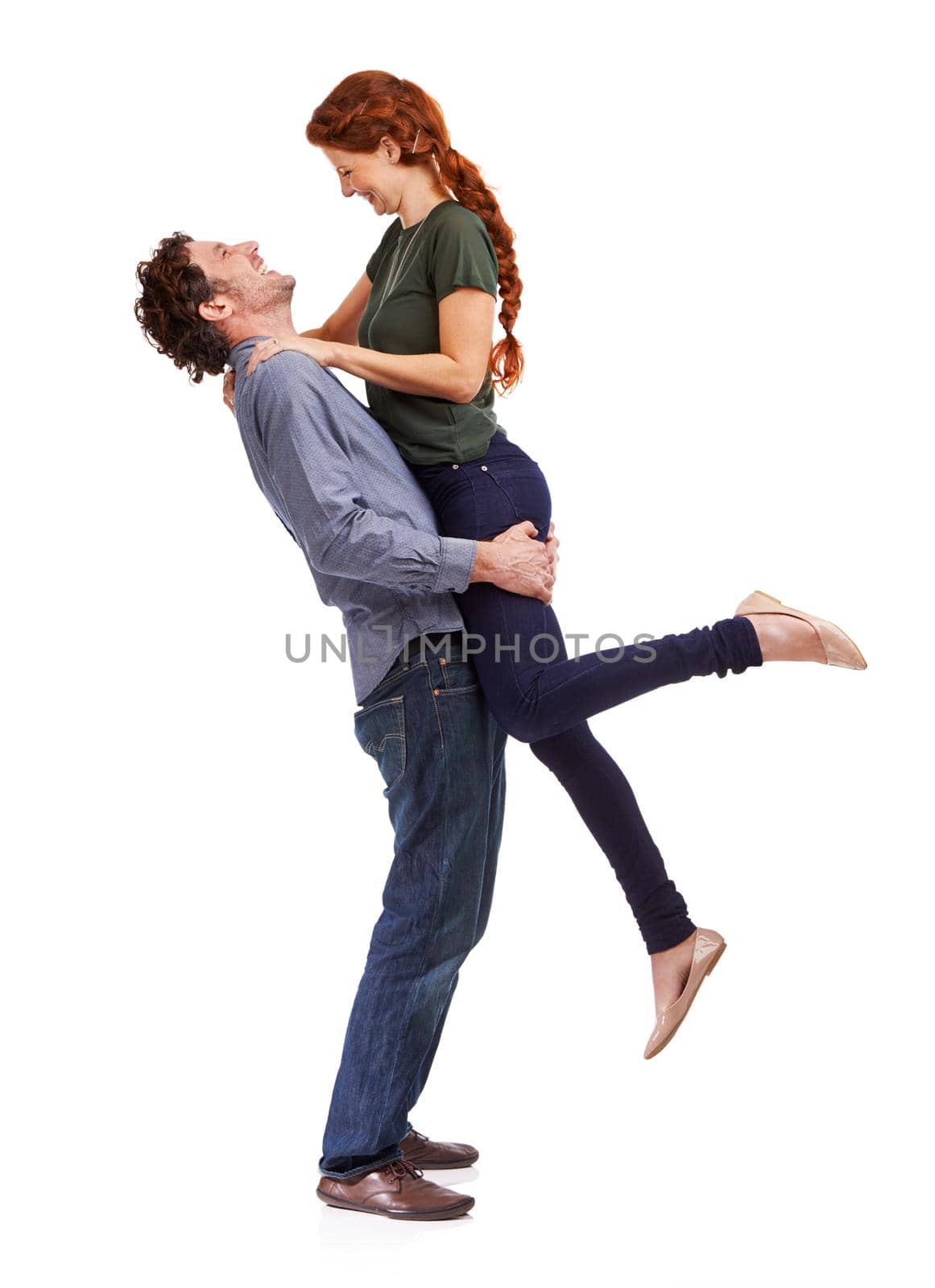 Love makes them feel alive. Full-length studio shot of a handsome man lifting up his girlfriend. by YuriArcurs