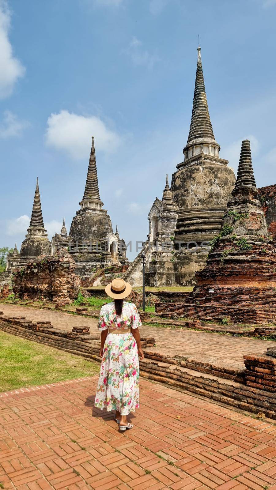 Women with hat tourist visit Ayutthaya, Thailand at Wat Chaiwatthanaram during sunset by fokkebok