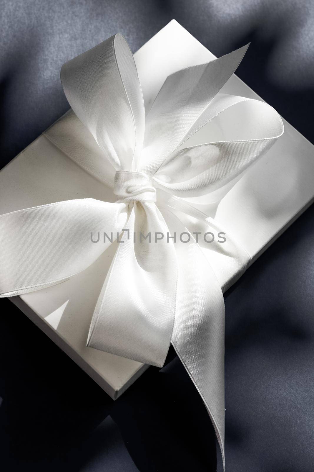 Anniversary celebration, shop sale promotion and luxe surprise concept - Luxury holiday white gift box with silk ribbon and bow on black background, luxe wedding or birthday present