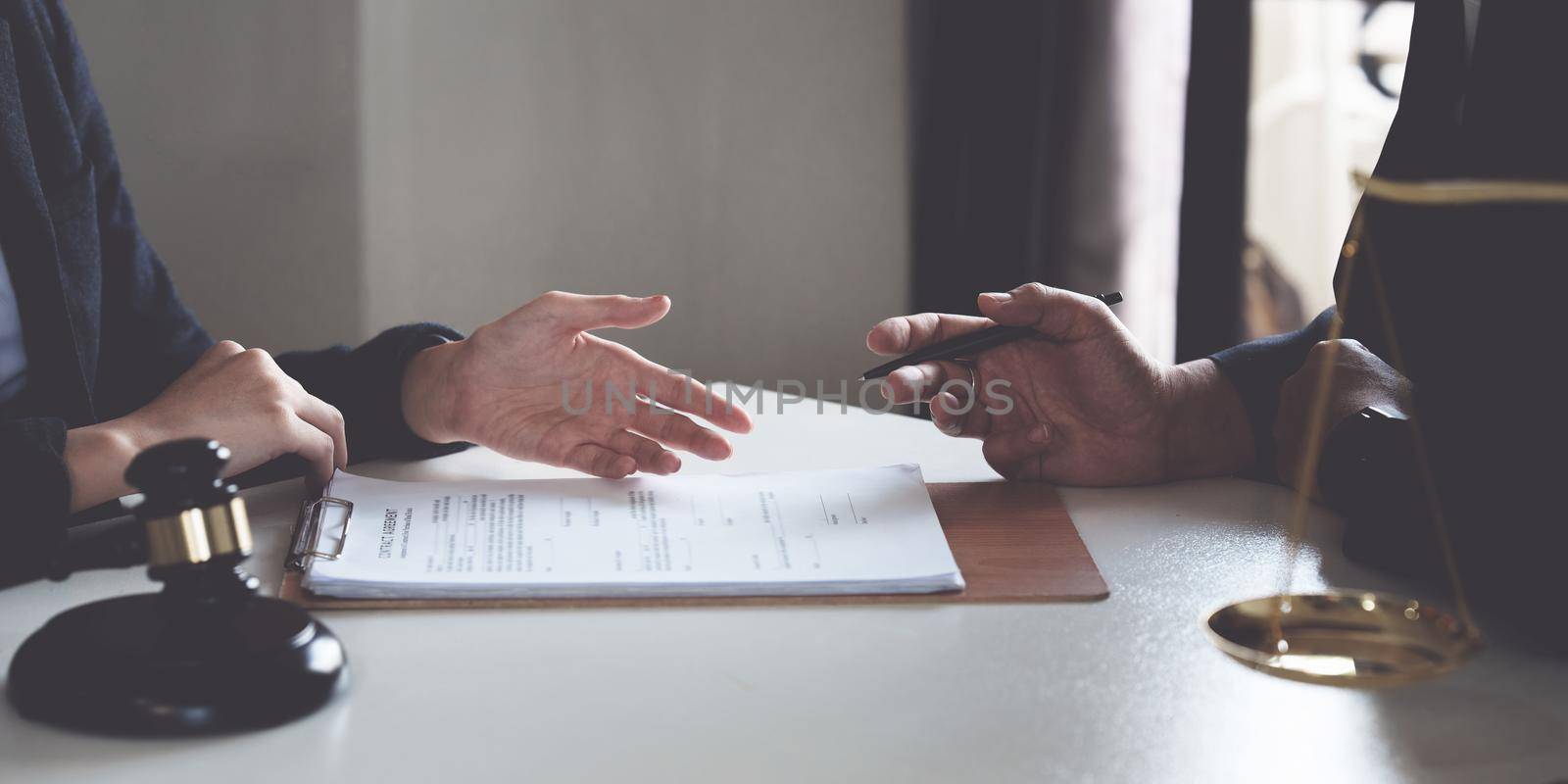 Business woman and lawyers discussing contract papers with brass scale on wooden desk in office. Law, legal services, advice, Justice concept.