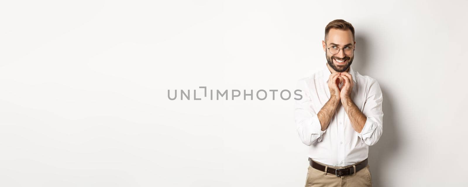 Young cunning businessman steeple fingers and smiling devious, scheming plan, standing over white background by Benzoix