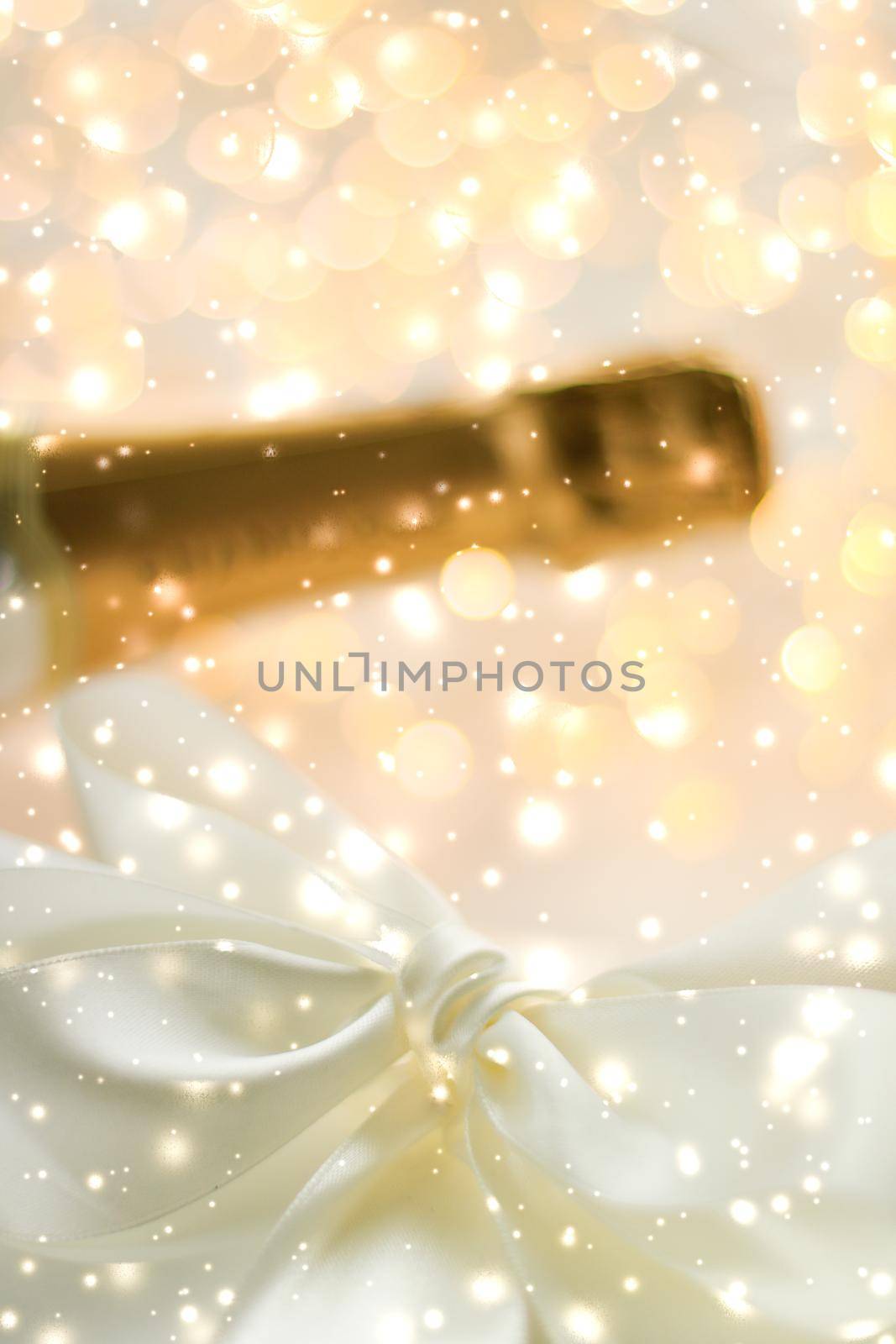 New Years Eve holiday champagne bottle and a gift box and shiny snow on marble background by Anneleven