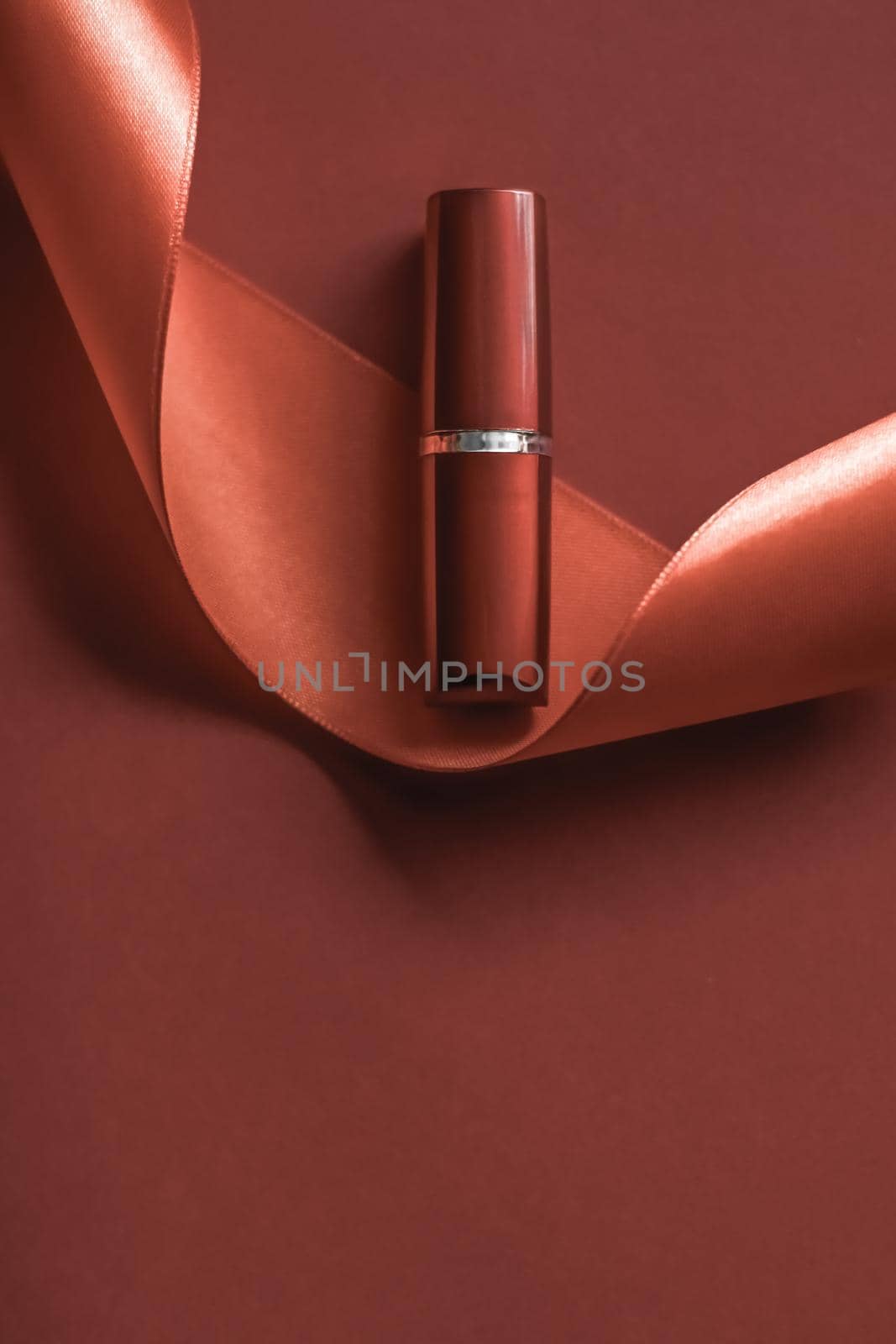 Cosmetic branding, glamour lip gloss and shopping sale concept - Luxury lipstick and silk ribbon on bronze holiday background, make-up and cosmetics flatlay for beauty brand product design