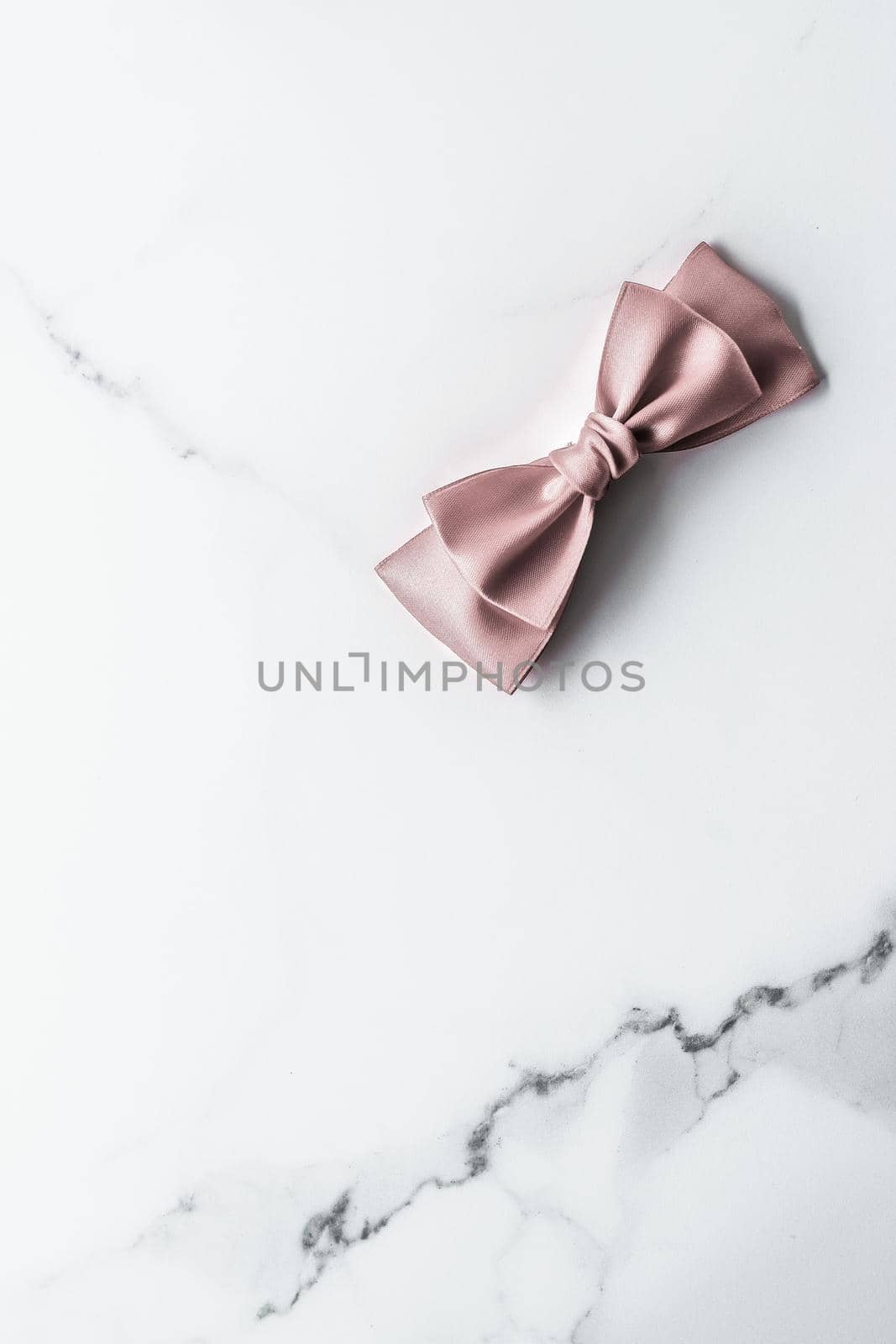 Beige silk ribbon and bow on marble background, glamour present mockup and fashion gift decoration for luxury beauty brand holiday flatlay design by Anneleven