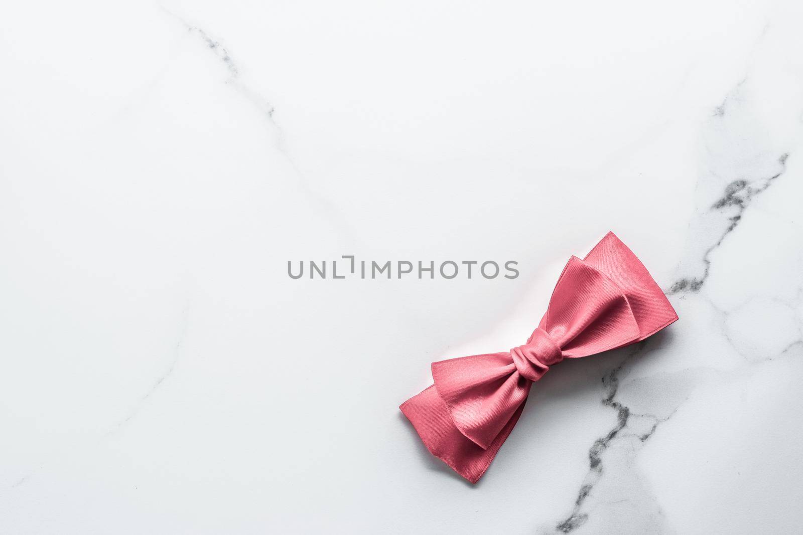Coral silk ribbon and bow on marble background, girl baby shower present and glamour fashion gift decor for luxury beauty brand, holiday flatlay design by Anneleven