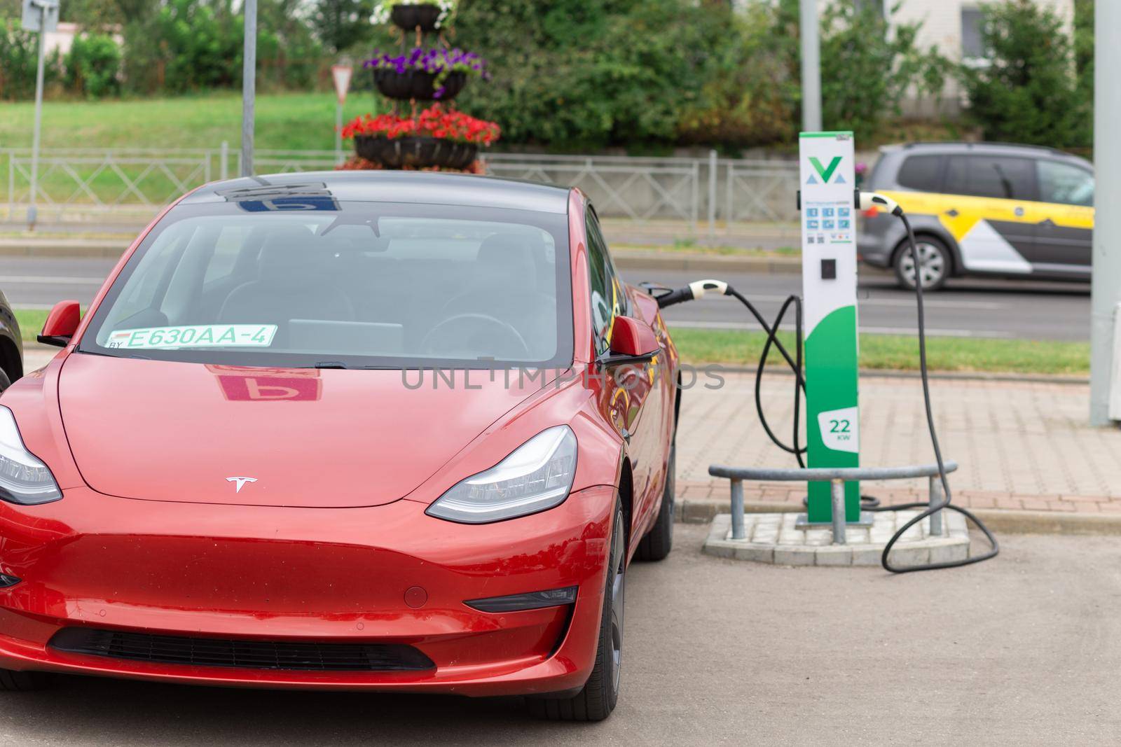 Grodno, Belarus - September 09, 2022: Tesla Model Y on 22W charging spot on Gorkogo st. - Car sharing commuter charging station. Charging technology industry transport which are the futuristic of the Automobile.