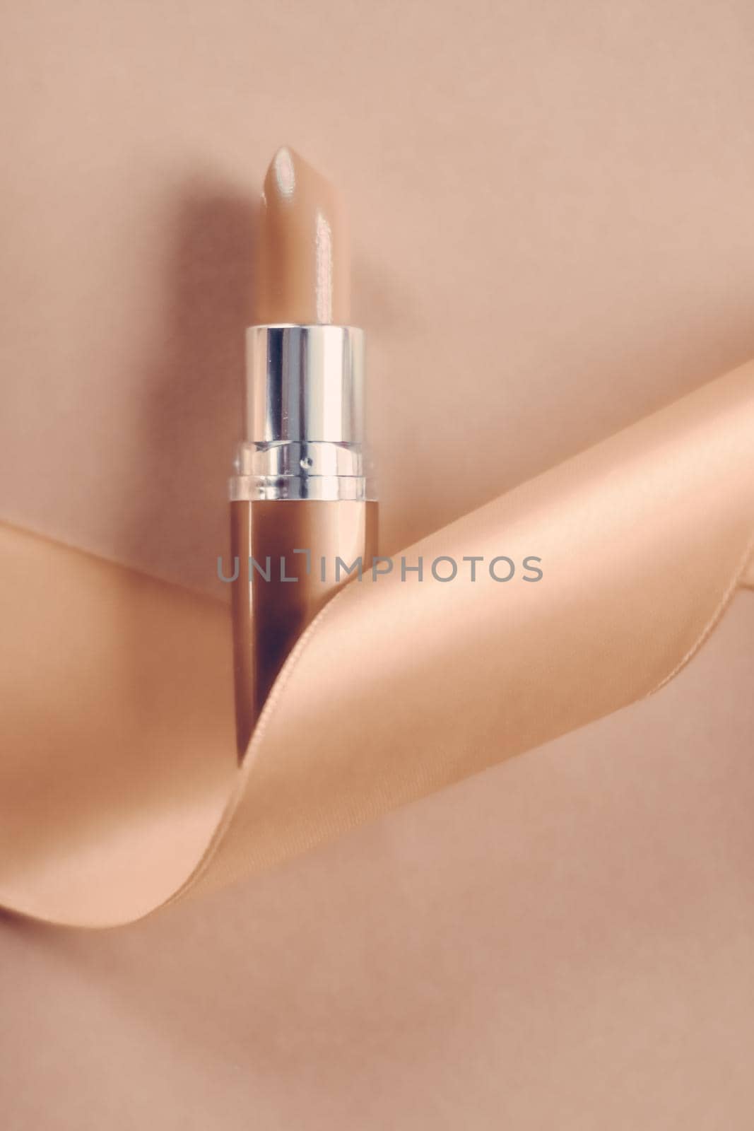 Cosmetic branding, glamour lip gloss and shopping sale concept - Luxury lipstick and silk ribbon on beige holiday background, make-up and cosmetics flatlay for beauty brand product design