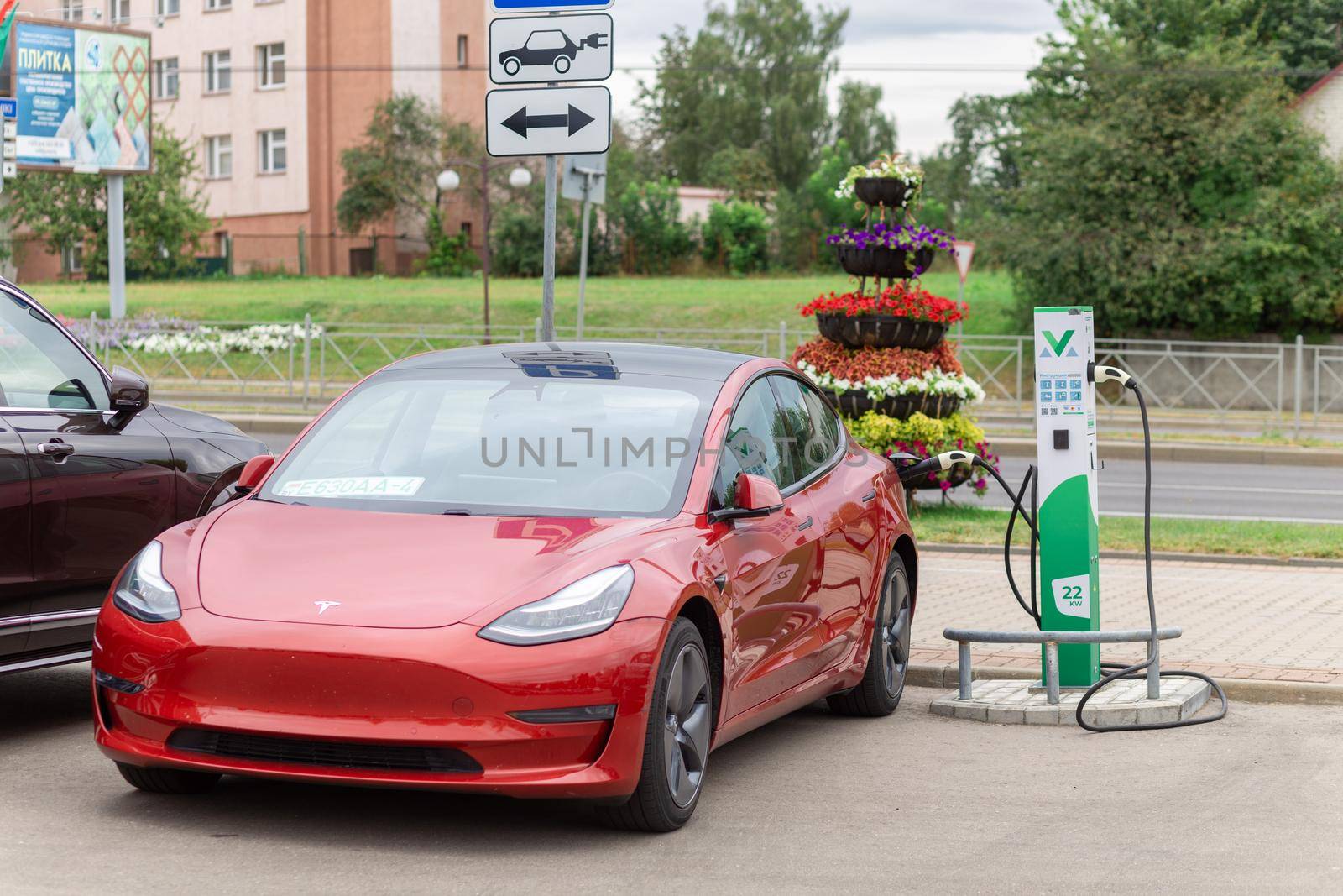 Grodno, Belarus - September 09, 2022: Tesla Model Y on 22W charging spot on Gorkogo st. - Car sharing commuter charging station. Charging technology industry transport which are the futuristic of the Automobile.