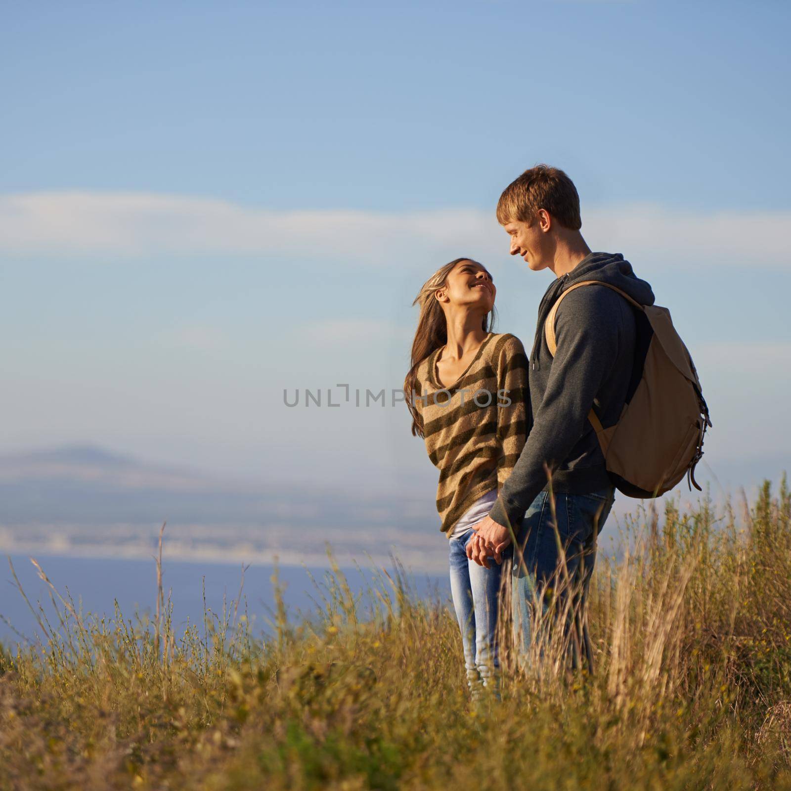 We should do this more often. a happy young couple standing on a hillside together