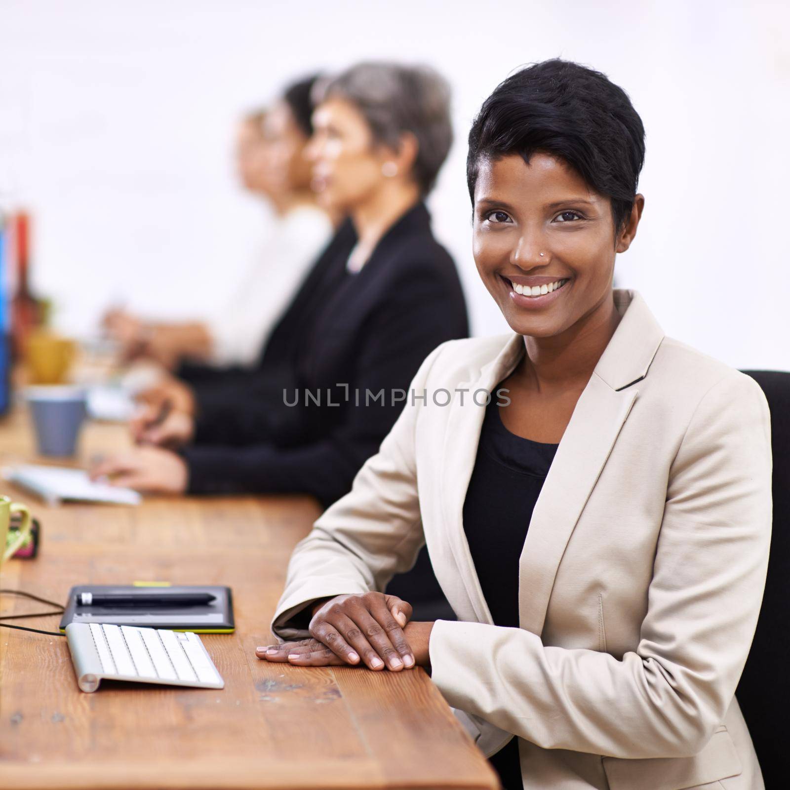 She really enjoys her work. Portrait of an attractive businesswoman sitting at a desk. by YuriArcurs