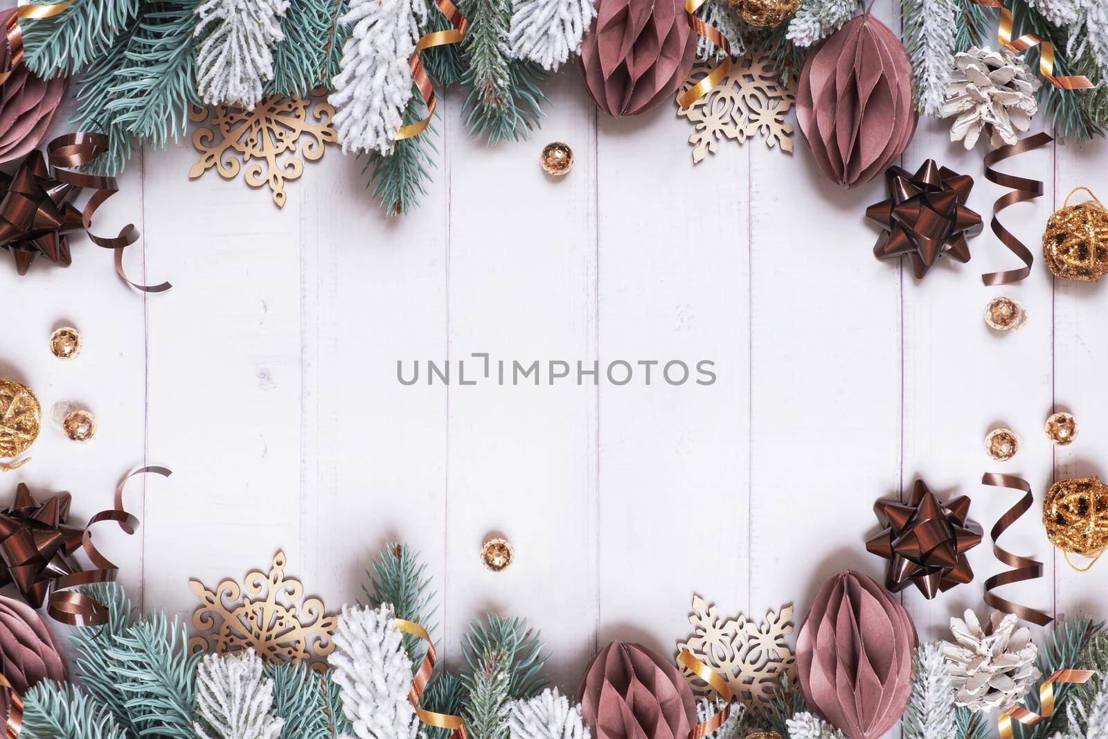 Christmas background with flat lay snow pine trees, paper and wooden Christmas toys on wooden background.