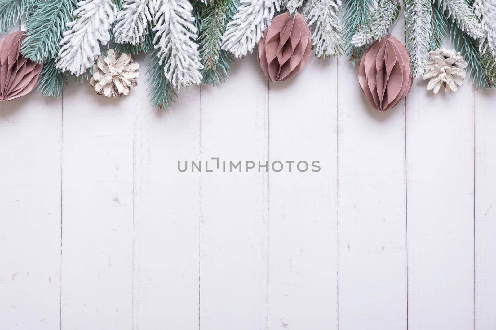 Christmas background with flat lay snow pine trees, paper Christmas toys on wooden background. High quality photo