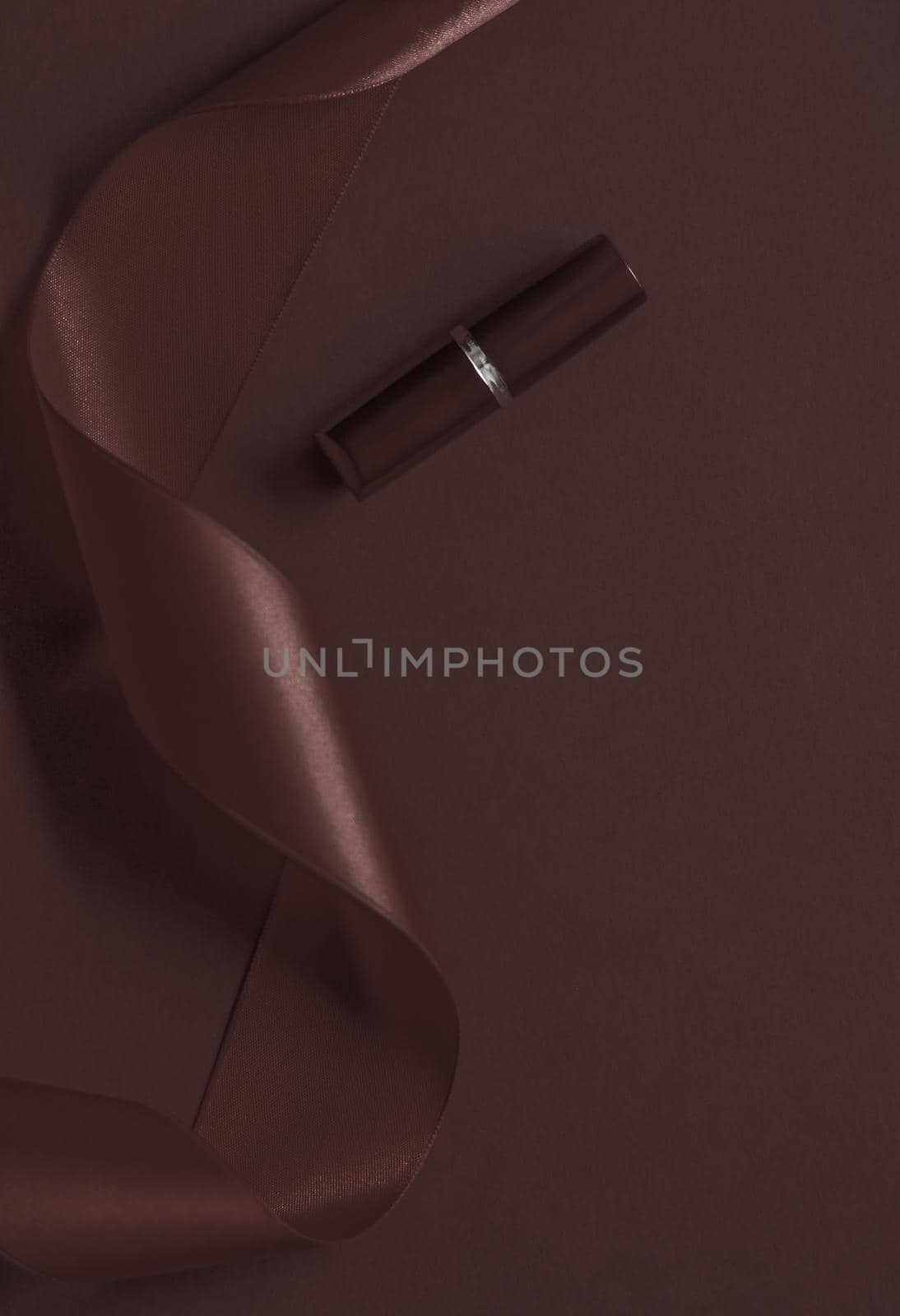 Luxury lipstick and silk ribbon on chocolate holiday background, make-up and cosmetics flatlay for beauty brand product design by Anneleven