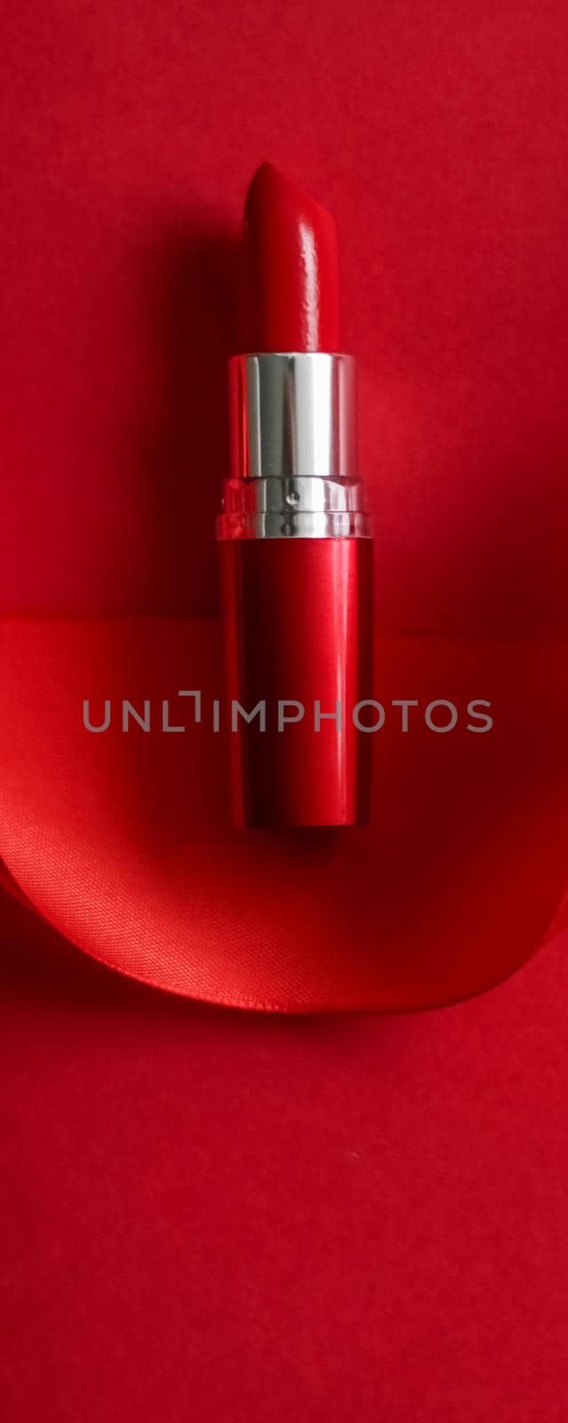 Cosmetic branding, glamour lip gloss and shopping sale concept - Luxury lipstick and silk ribbon on red holiday background, make-up and cosmetics flatlay for beauty brand product design