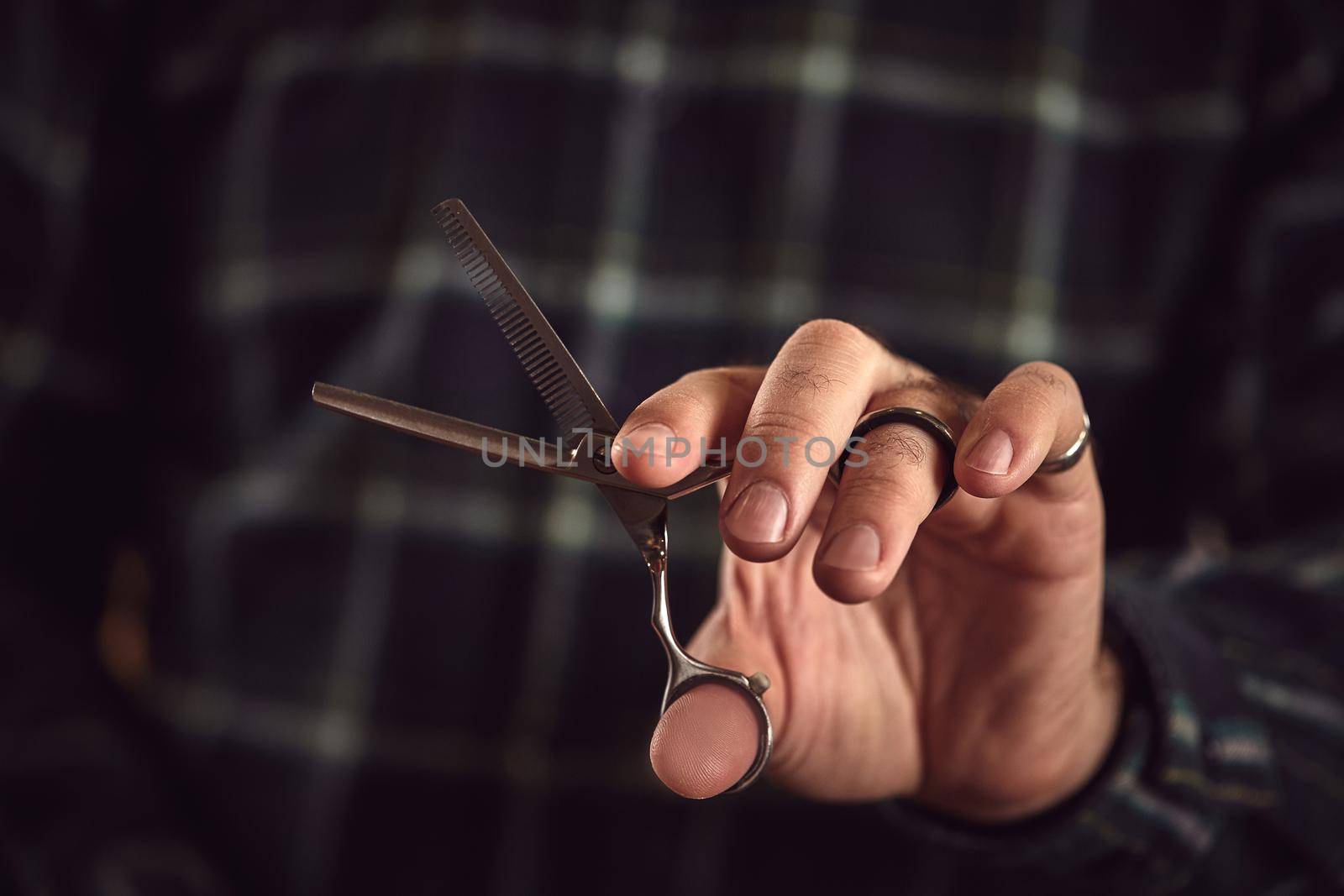 Man hairdresser. Barber is holding scissors in his hands barbershop.