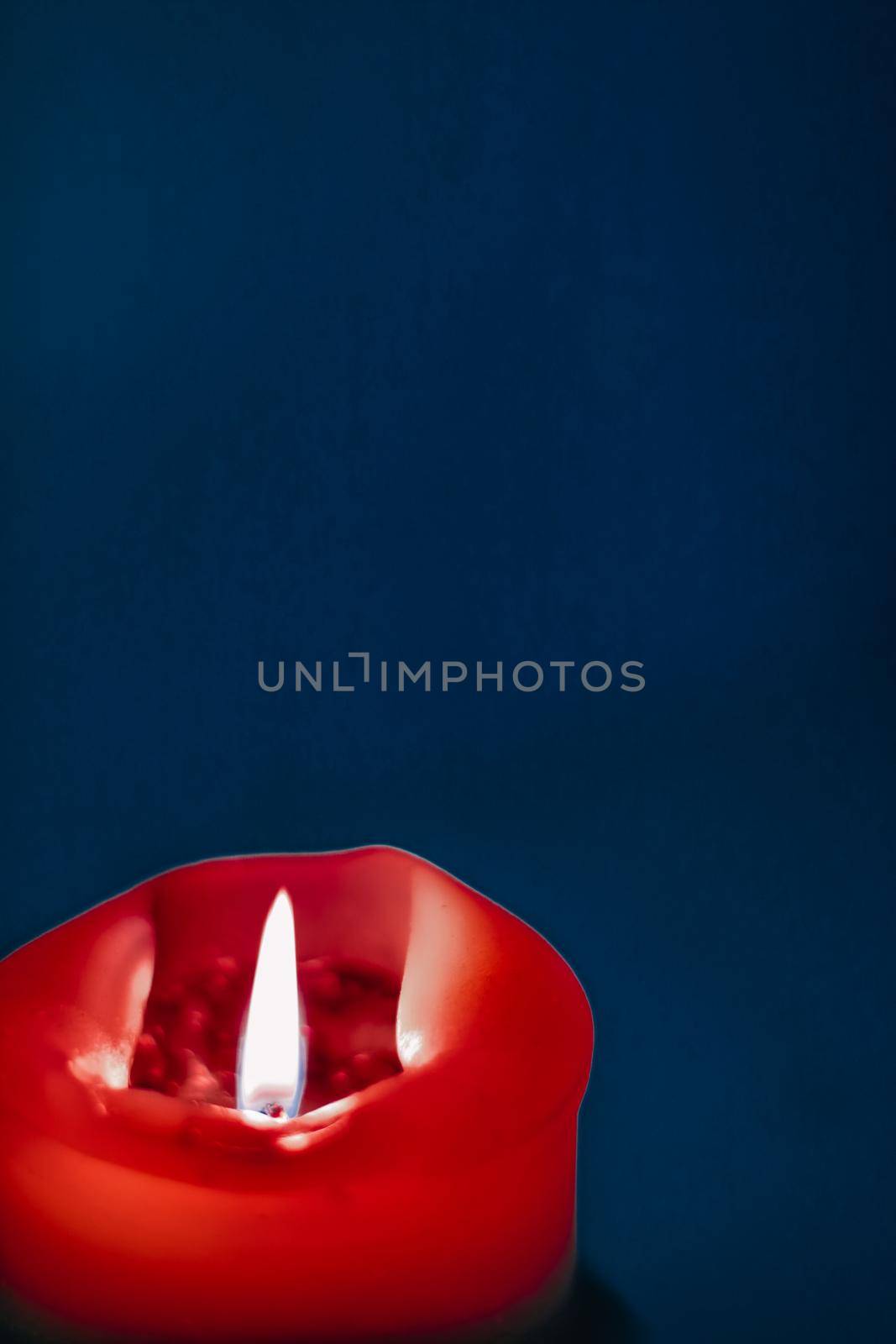 Happy holidays, greeting card backdrop and winter season concept - Red holiday candle on blue background, luxury branding design and decoration for Christmas, New Years Eve and Valentines Day