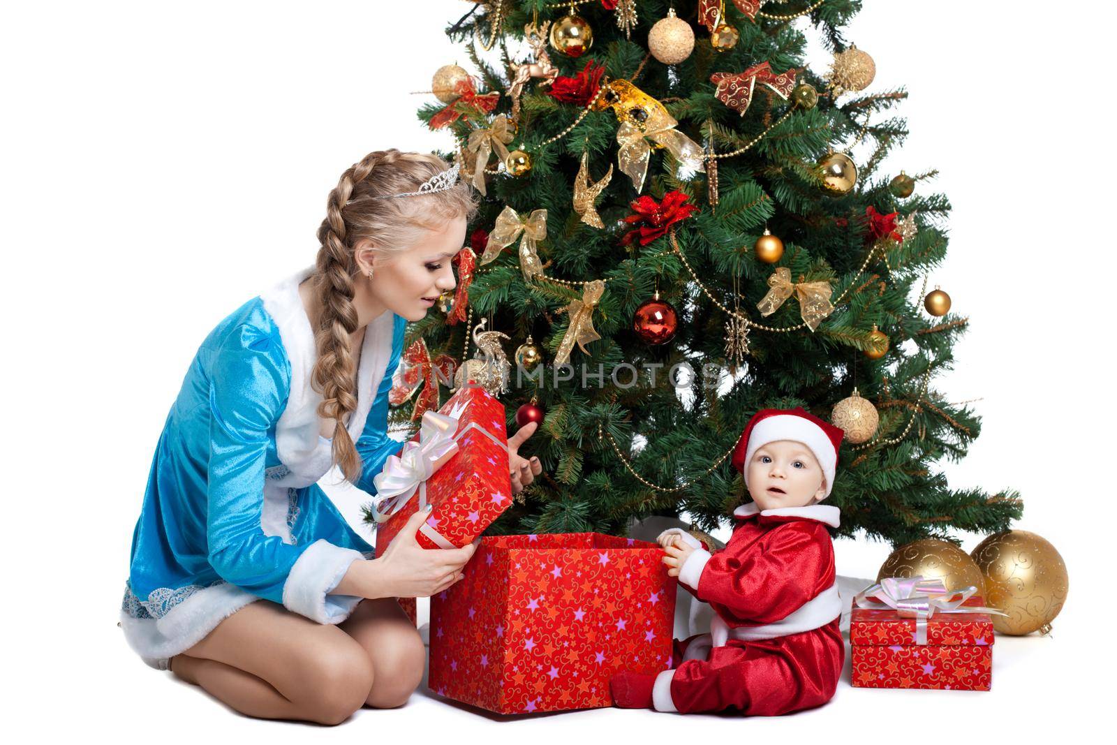 Beauty christmas girl in blue cloth play with baby santa claus near tree and gifts