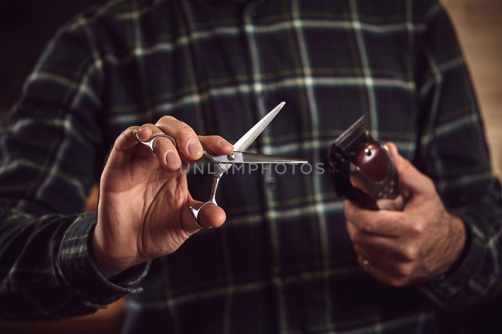 Man hairdresser. Barber is holding scissors and razor in his hands barbershop.