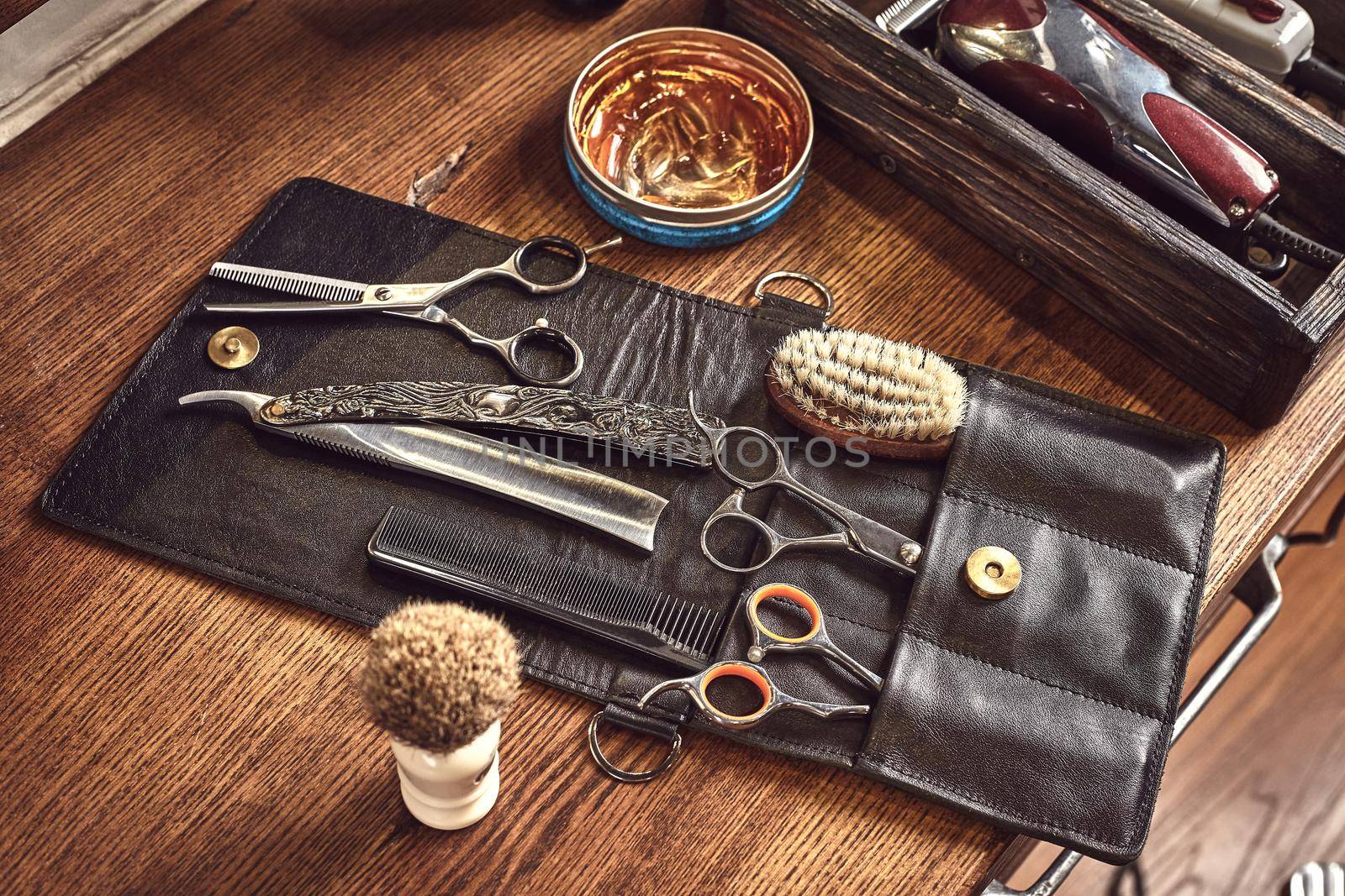 Hairdresser tools on wooden background. Top view on wooden table with scissors, comb, hairbrushes and hairclips, trimmer. Barbershop, manhood concept