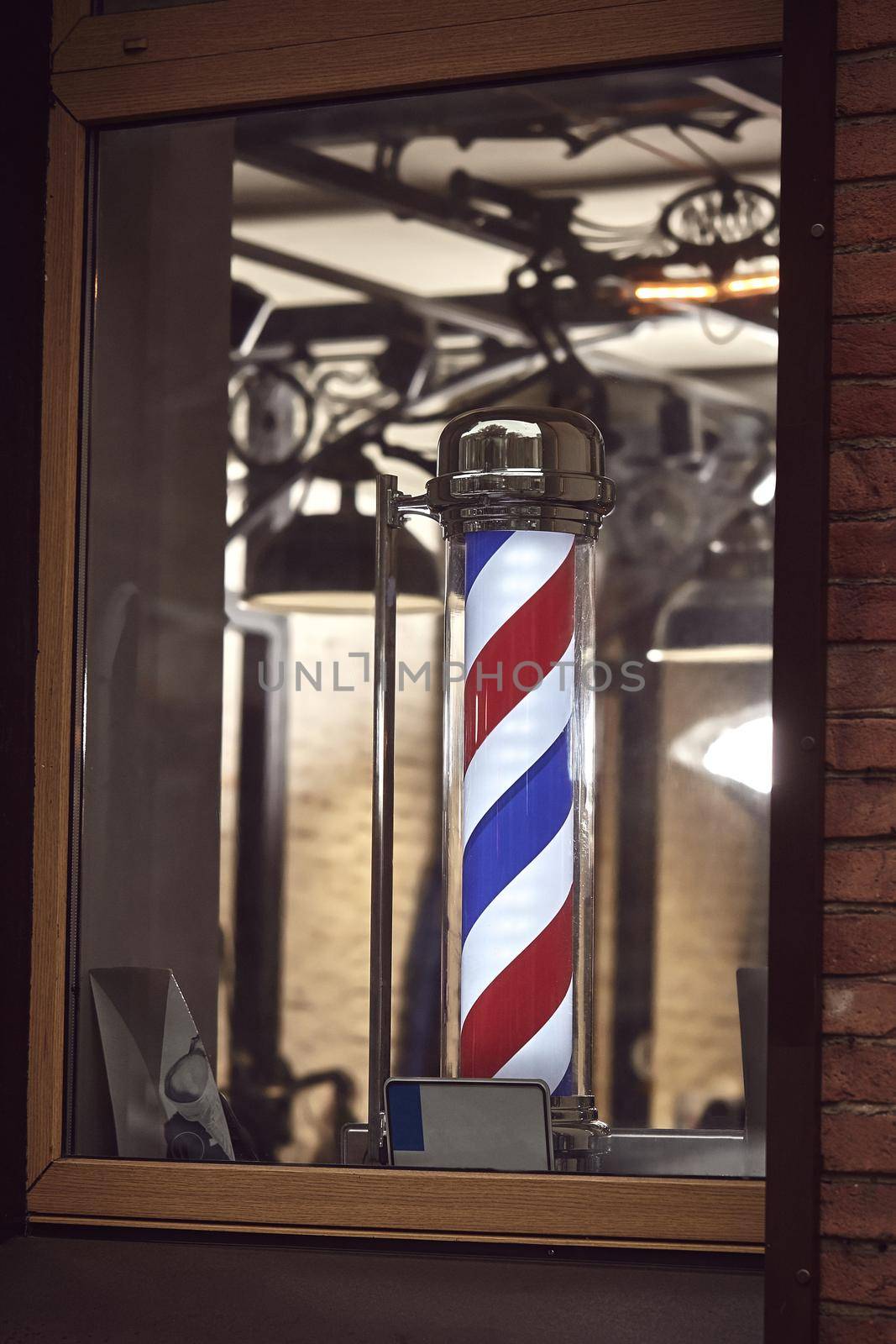 The famous symbol of a barber shop with it swirling red, blue and white stripes. by nazarovsergey