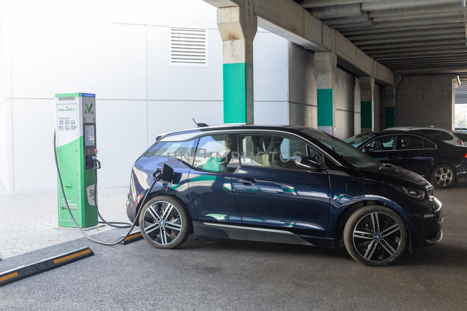 Grodno, Belarus - September 09, 2022: BMW i3 on 50kW fast charging spot Malanka on parking of the Triniti shoping mall - Car sharing commuter charging station. Charging technology industry transport which are the futuristic of the Automobile.