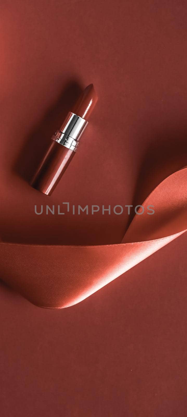 Cosmetic branding, glamour lip gloss and shopping sale concept - Luxury lipstick and silk ribbon on bronze holiday background, make-up and cosmetics flatlay for beauty brand product design