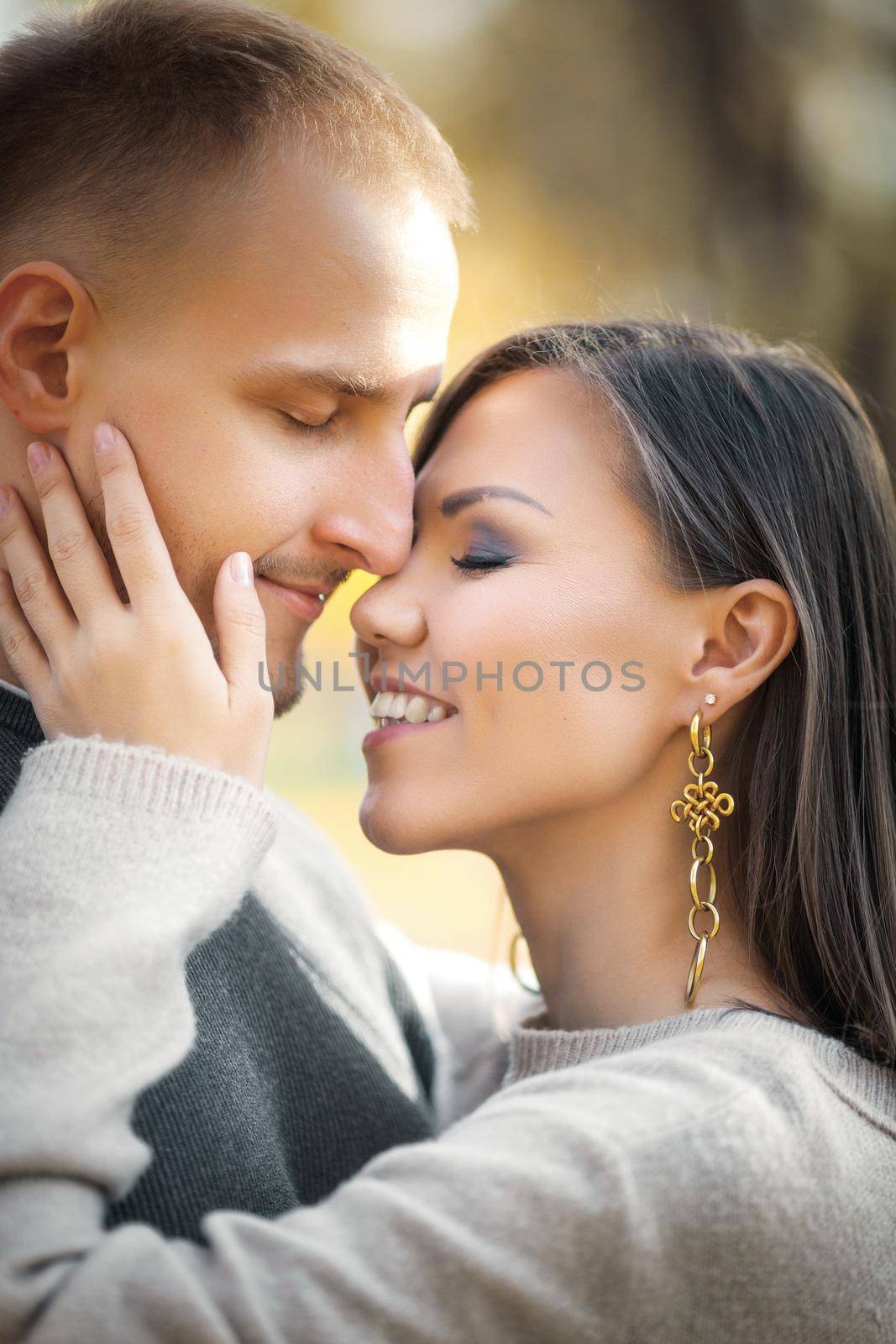 Cute romantic young couple hugging tenderly in autumn nature.